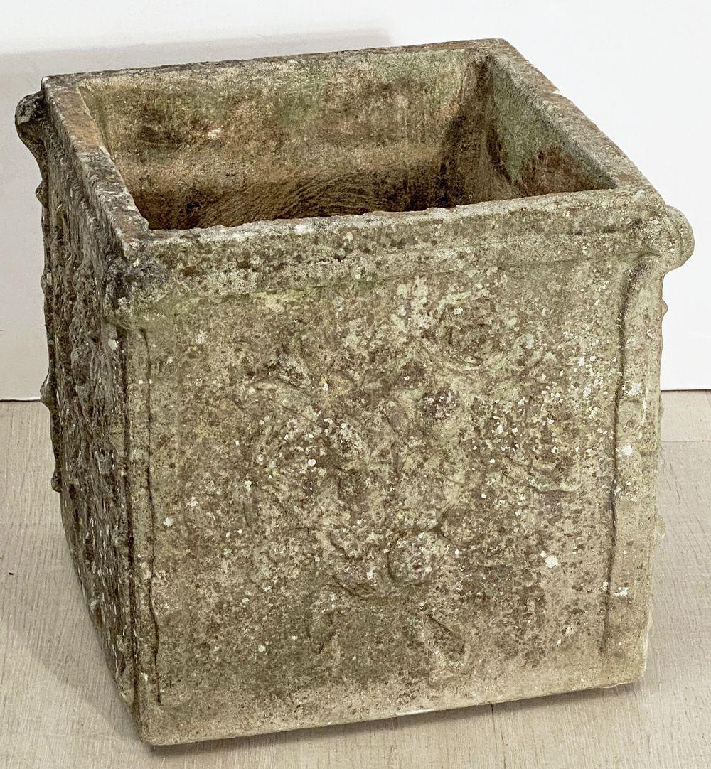 A fine large English square garden planter or pot of composition stone with a floral relief to all four sides.
