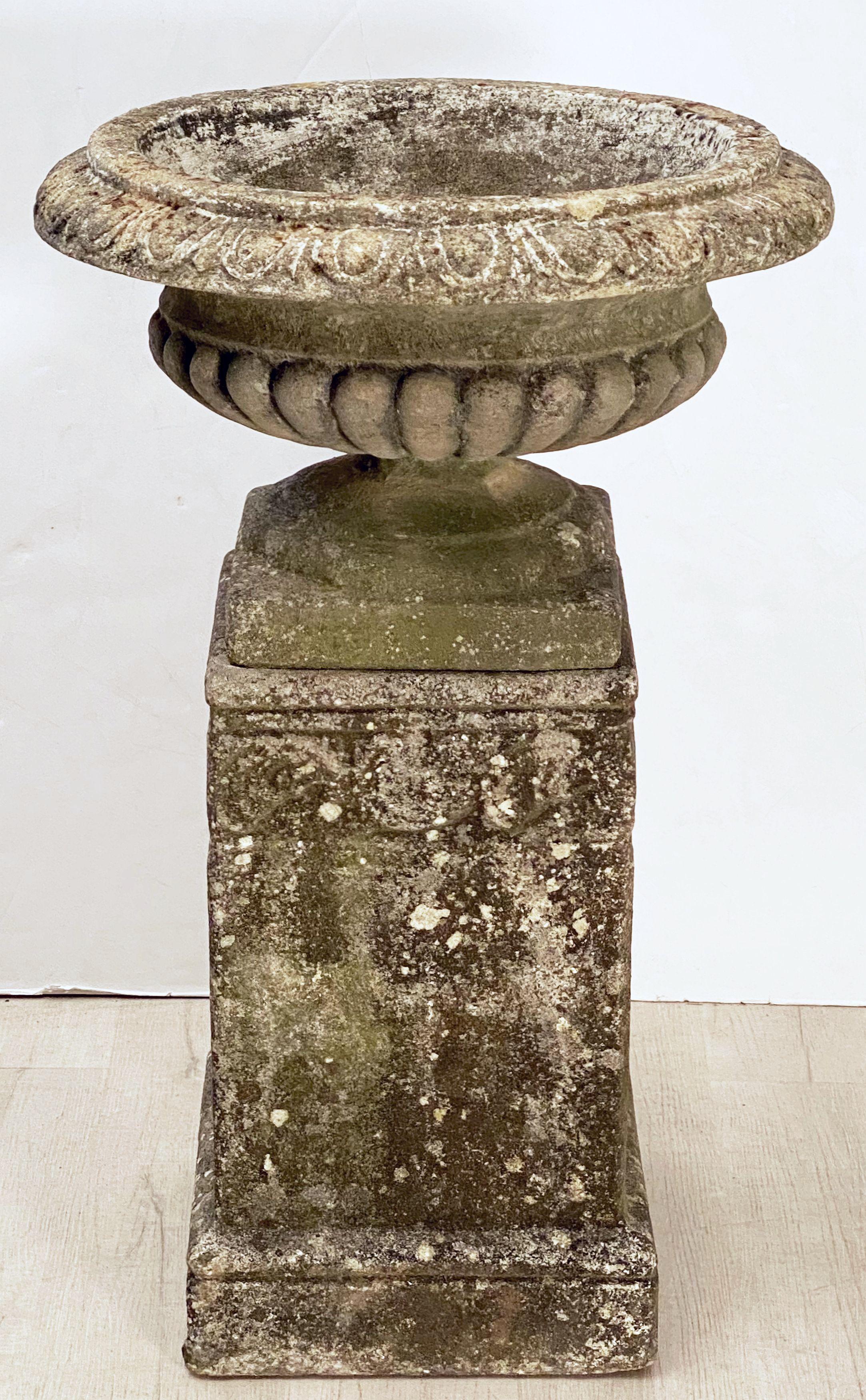A fine English garden urn (or planter pot) on plinth of composition stone in the Classical style, featuring an urn with semi-lobed body on raised square base, set upon a square plinth with a scrollwork design to the sides.

Perfect for a garden room