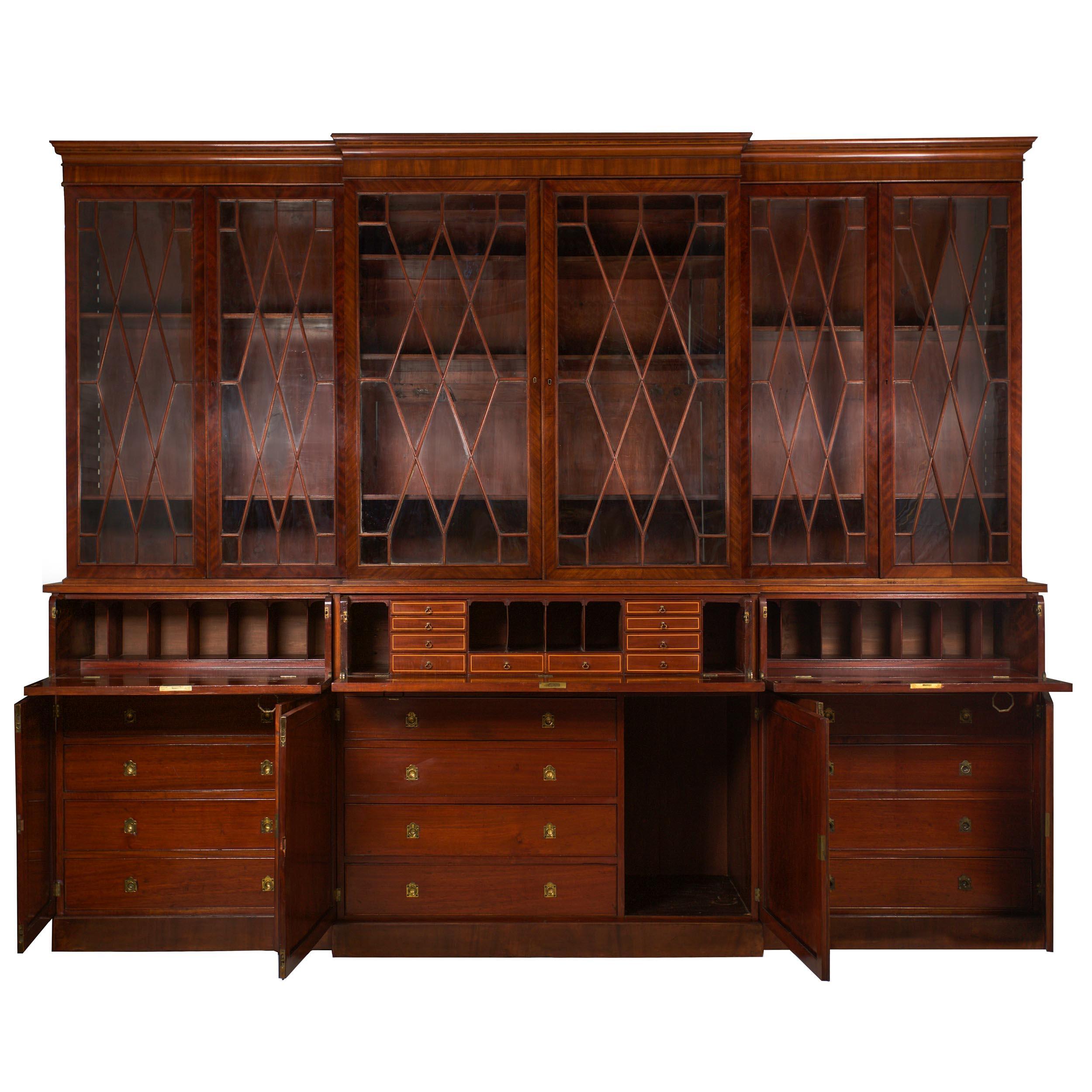 A remarkably large library breakfront bookcase of the George III taste from the second quarter of the 19th century, this imposing cabinet is the very essence of presence. With glazed doors portioned with applied astragal moldings, the three bookcase