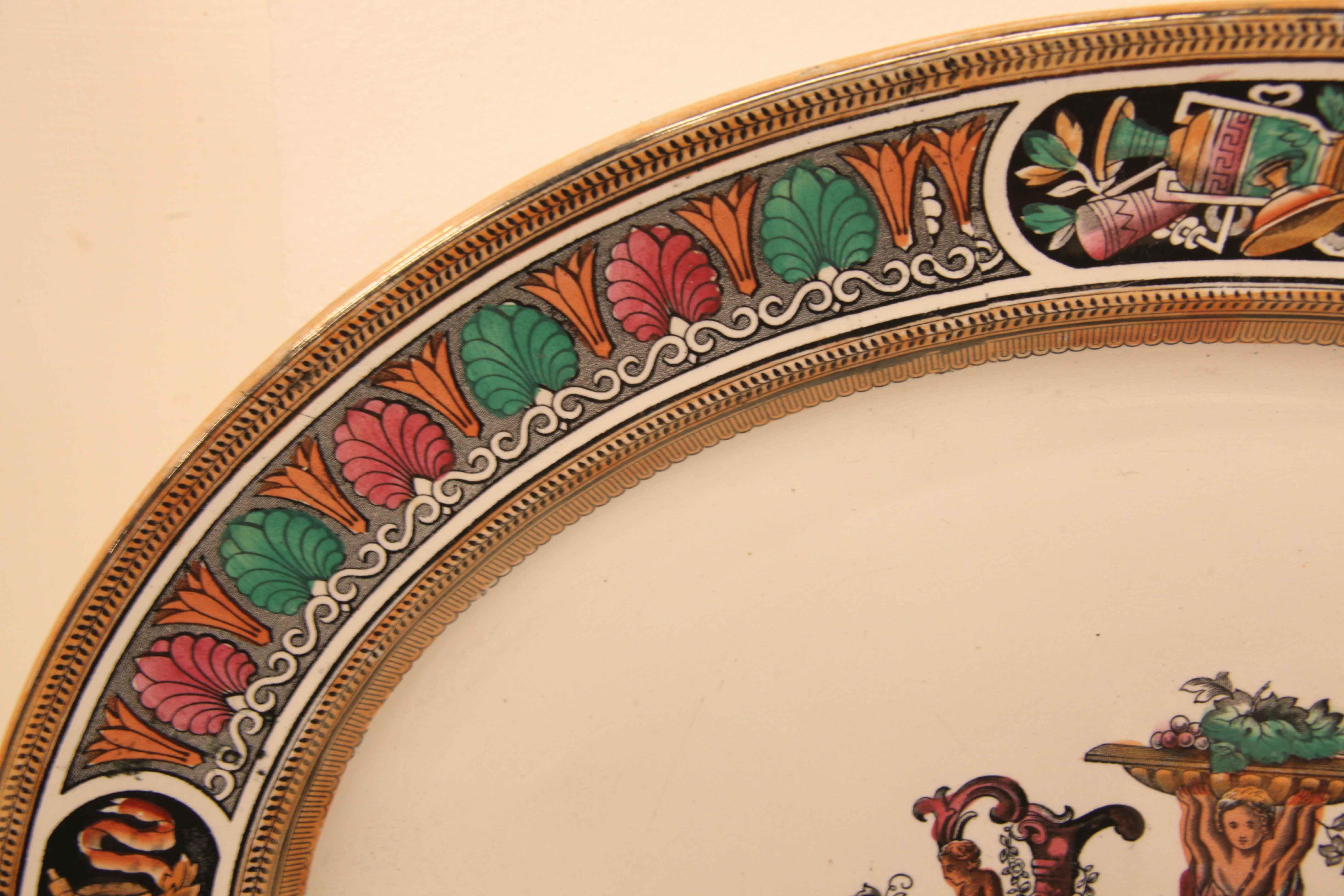Large English ironstone platter, the outer rim and inner border have a black leaf pattern on a salmon colored background, the main border has alternating motifs in rose, teal and orange interrupted with four cartouches featuring an oriental vase and