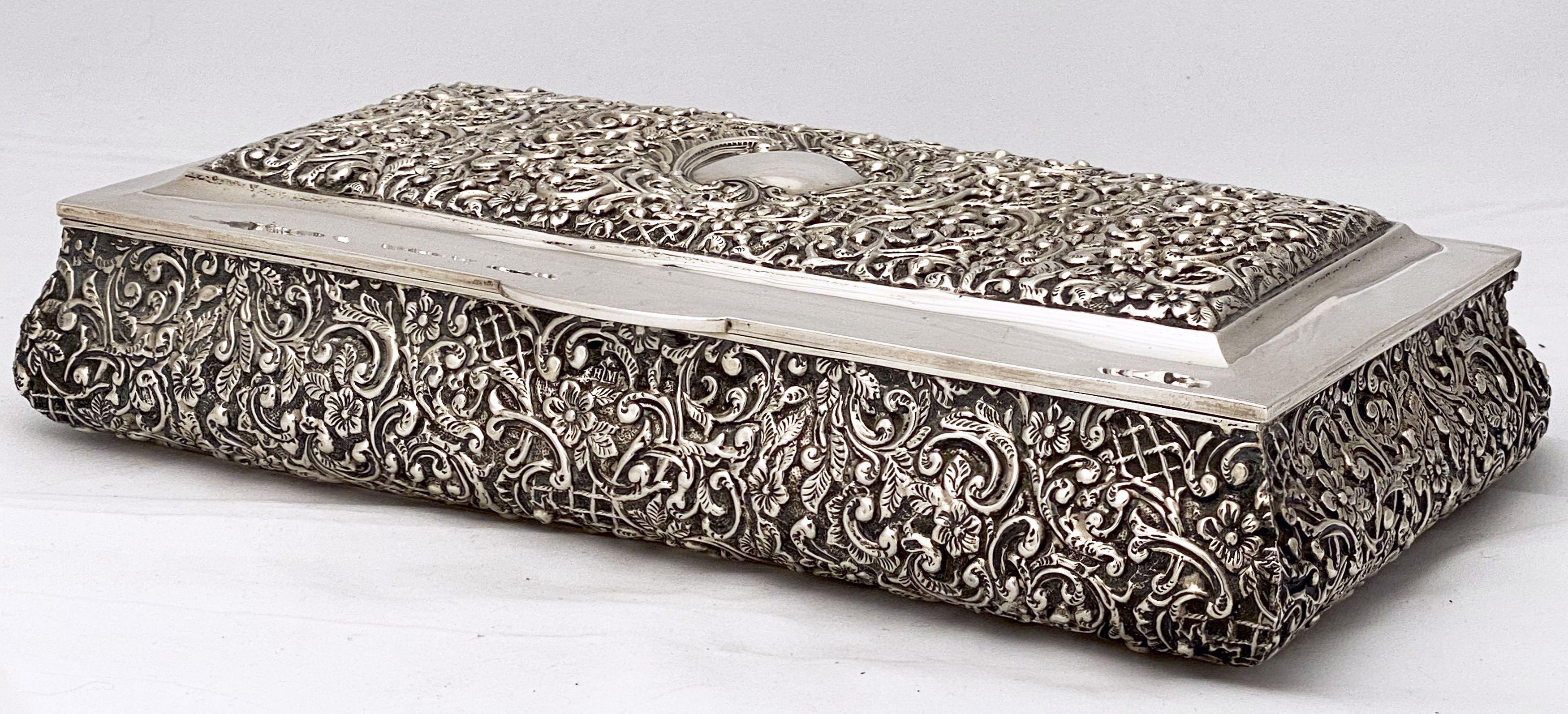 A finely chased rectangular jewelry box of Sterling silver from the Edwardian era by the celebrated English silversmiths, Henry Matthews. hallmarks for Birmingham, c.1903. Featuring an embossed top and sides with a foliate design of flowers and
