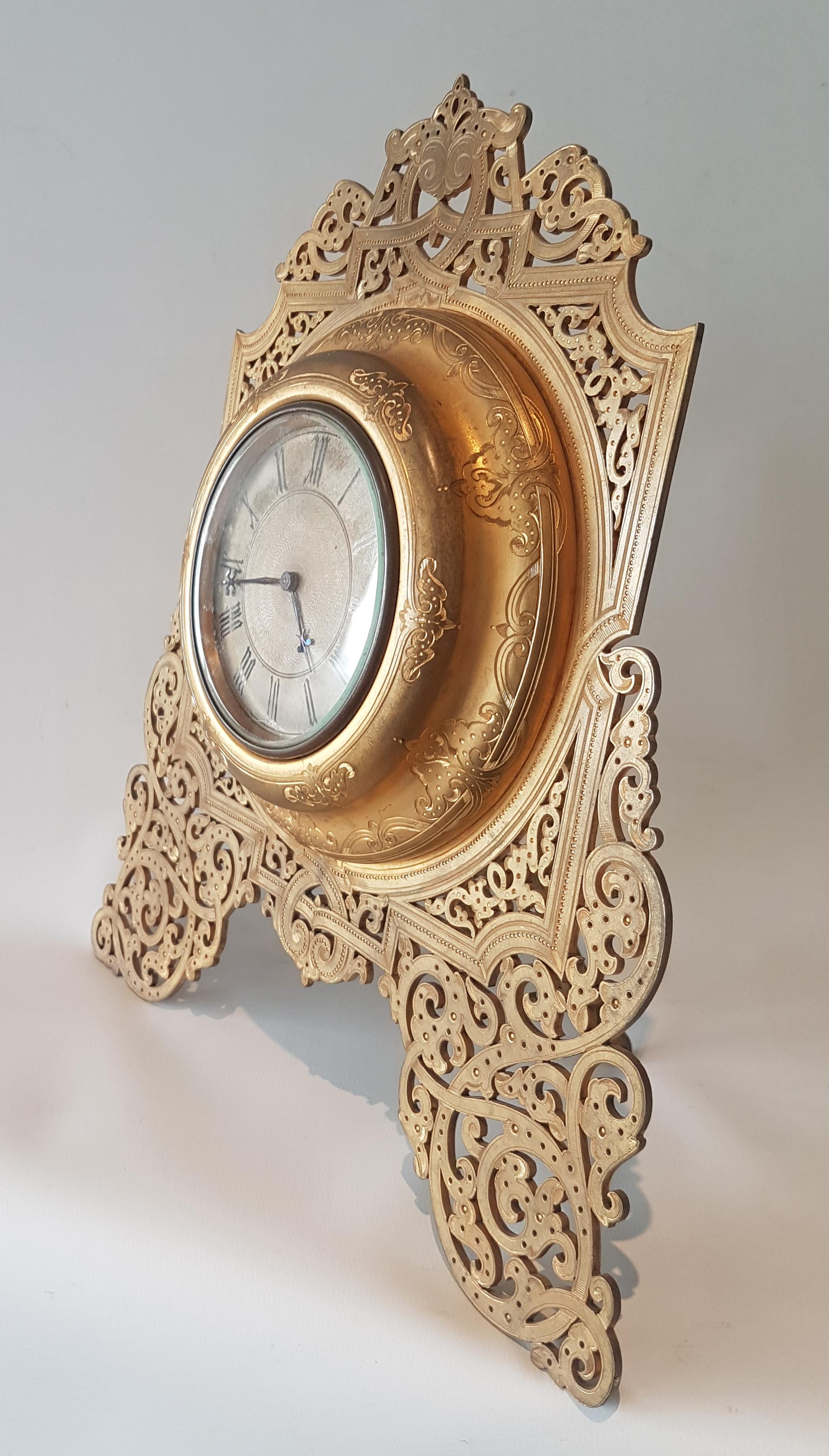 Large beautifully cut and engraved ormolu English Victorian strut clock in the manner of Cole. Silvered dial with engine turned centre with beautifully cut blued steel hands. 8 day lever movement.