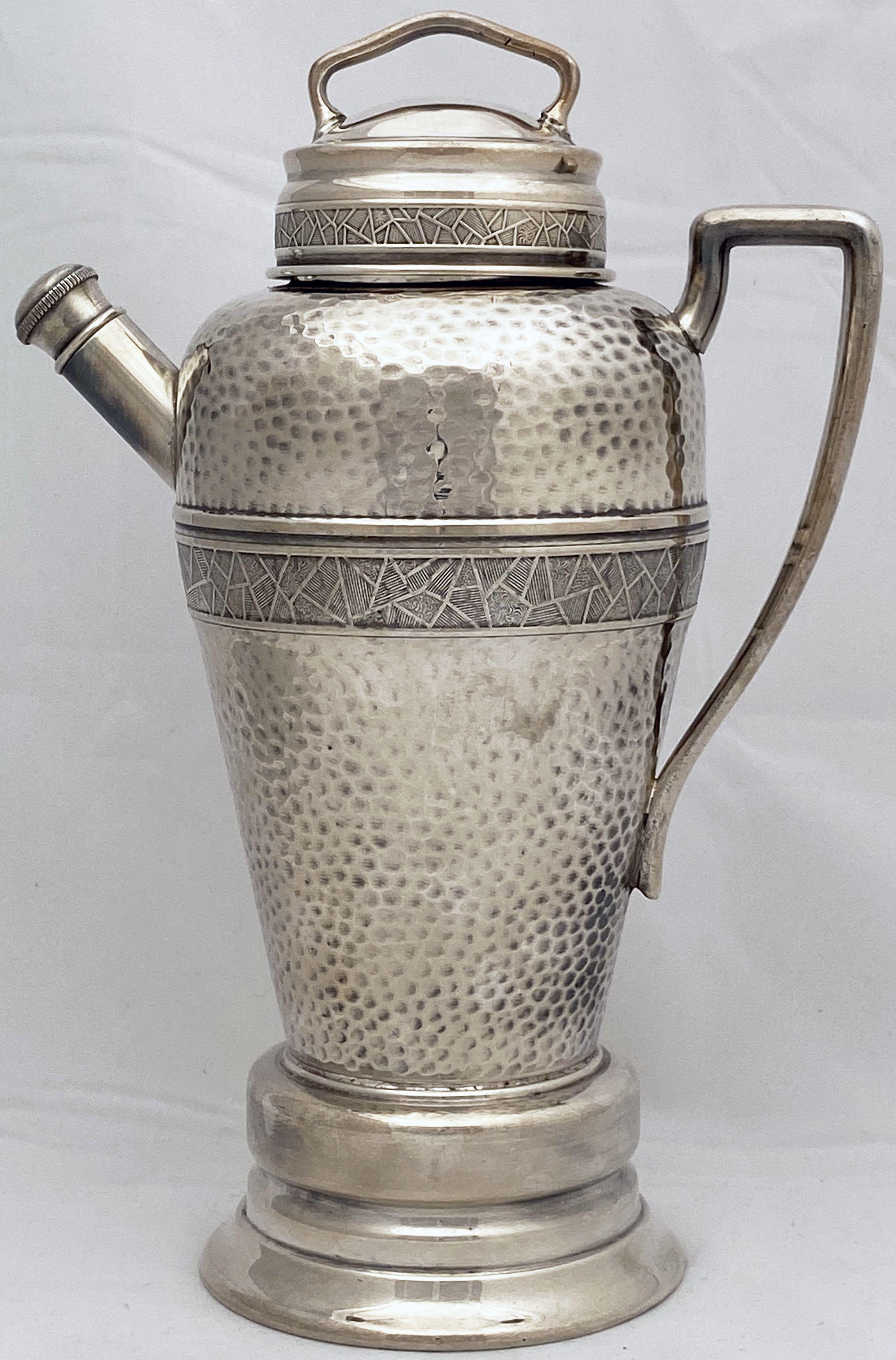 A large English martini or cocktail shaker of fine plate silver from the Art Deco era with a music box under the base, featuring a hammered body of tapering form, removable top and pour spout with screw-down cap, angular handle, and decorative