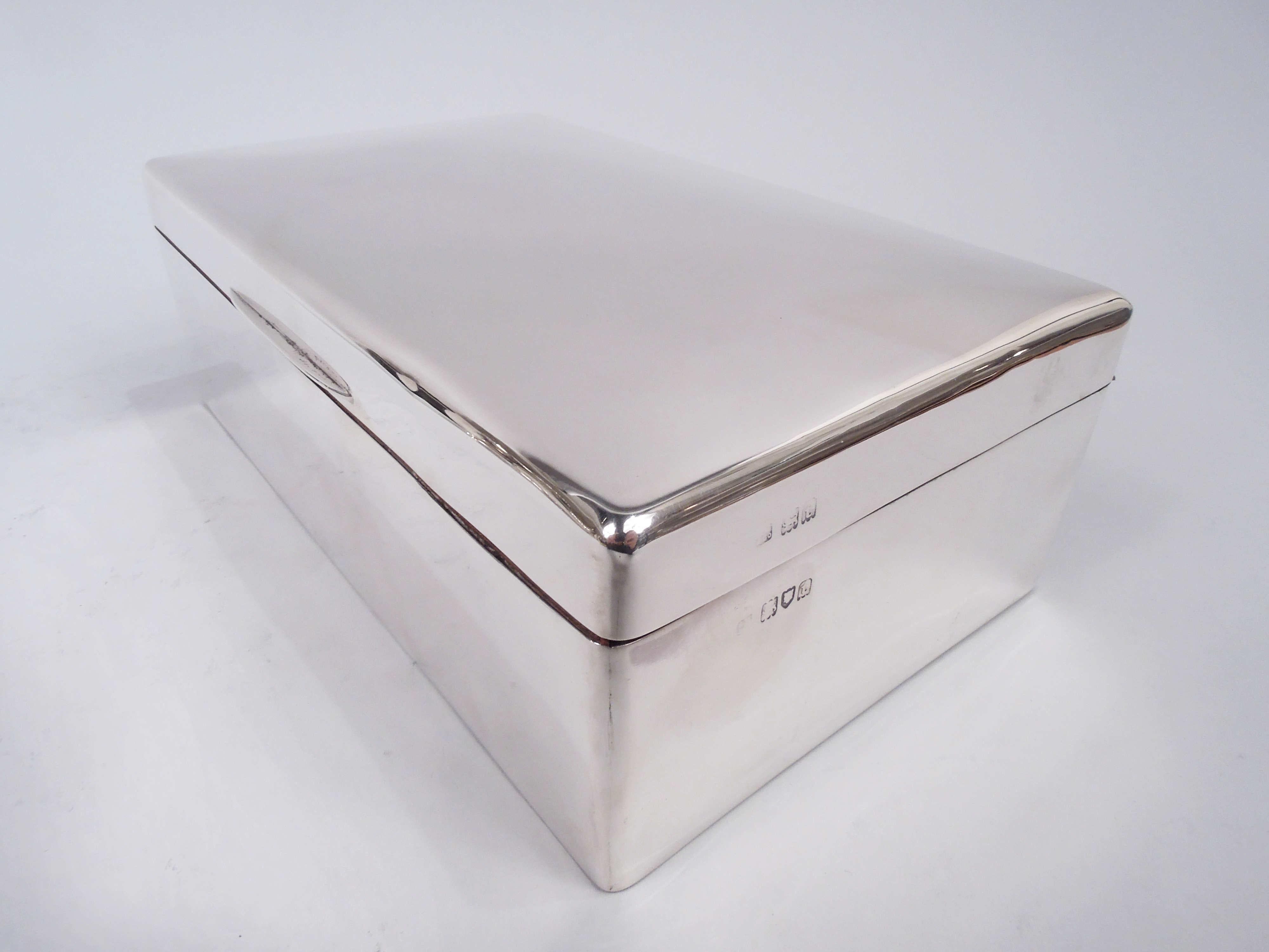 George V sterling silver box. Made by Sampson Mordan in London in 1914. Rectangular with straight sides and curved corners. Cover hinged with tapering tab and gently curved top. Cedar-lined and partitioned interior. Leather-lined underside. Fully