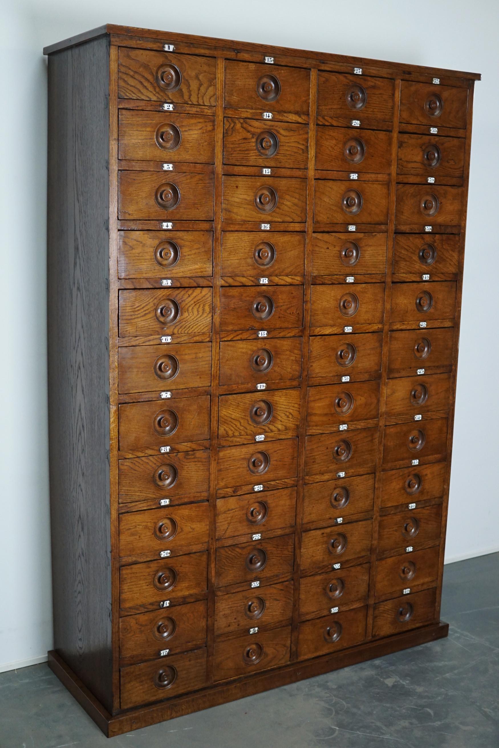 This apothecary cabinet was made circa 1920s in England. It features 48 drawers with amazing wooden knobs and enamel numbers. The interior dimensions of the drawers are: D x W x H 40 x 25 x 11 cm.