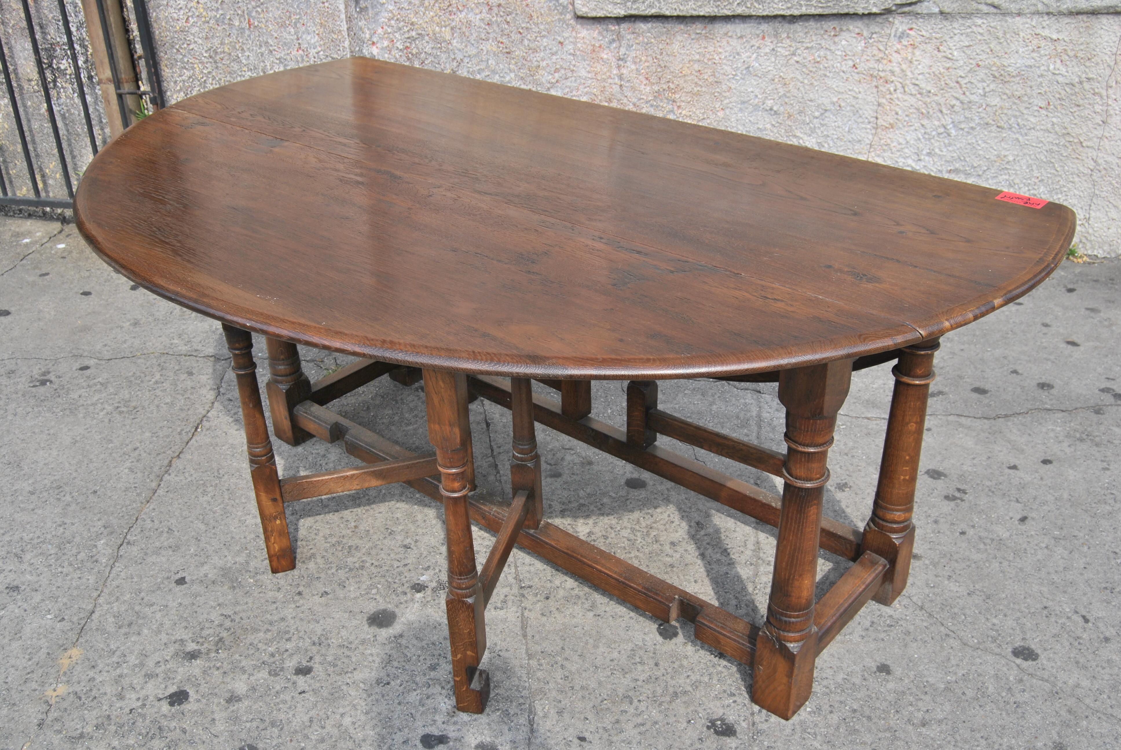 This is a solid oak gate leg table made in England, circa 1950. This table is also known as a Wake Table, a Hunt Table, a Hall Table, a drop-leaf table or sofa table. It is a very useful table in many situations. This table was bench made (all