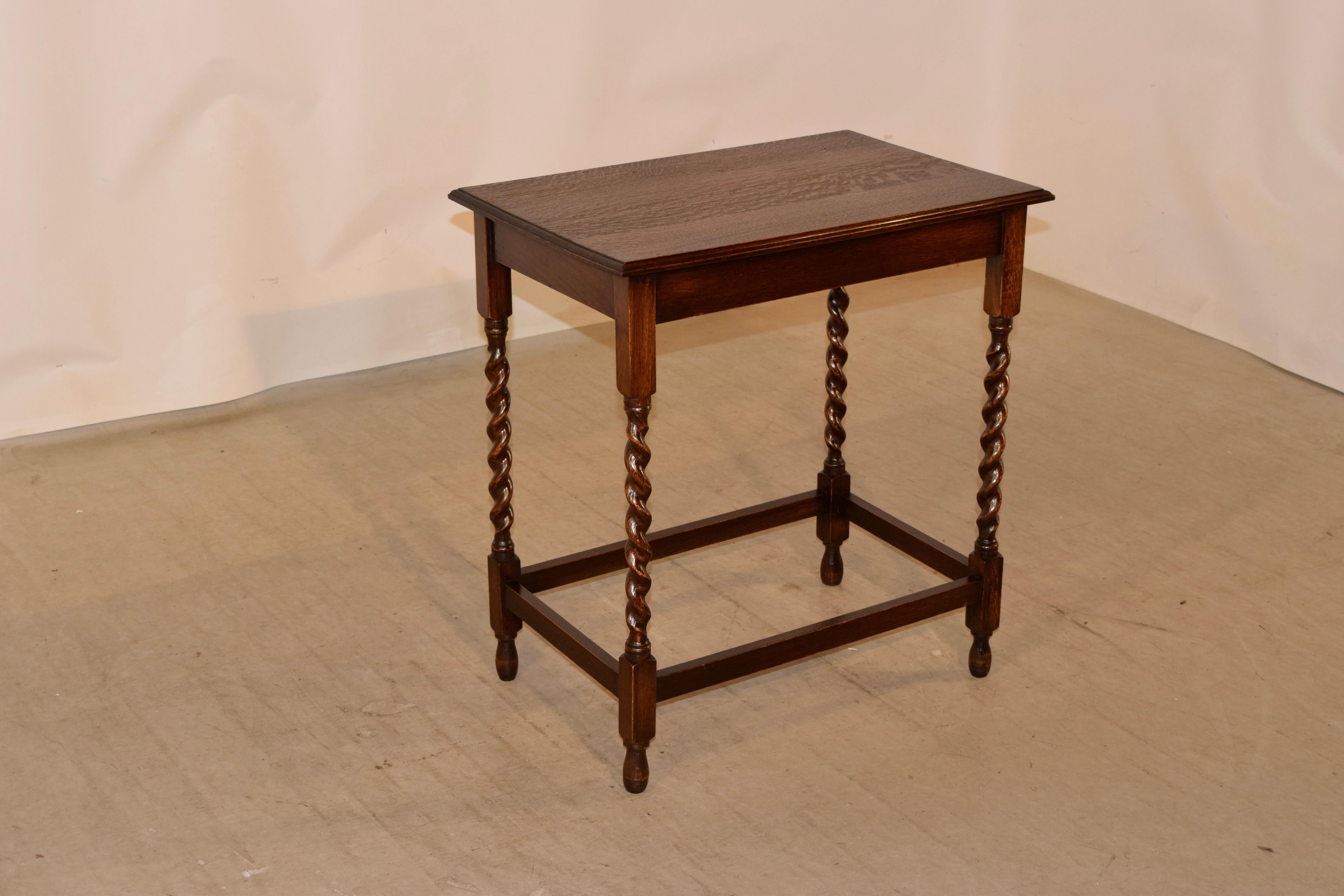 Large oak occasional table from England, c. 1900 with a beveled edge around the top, following down to a simple apron and supported on hand turned barley twist legs, joined by simple stretchers. Raised on hand turned feet.