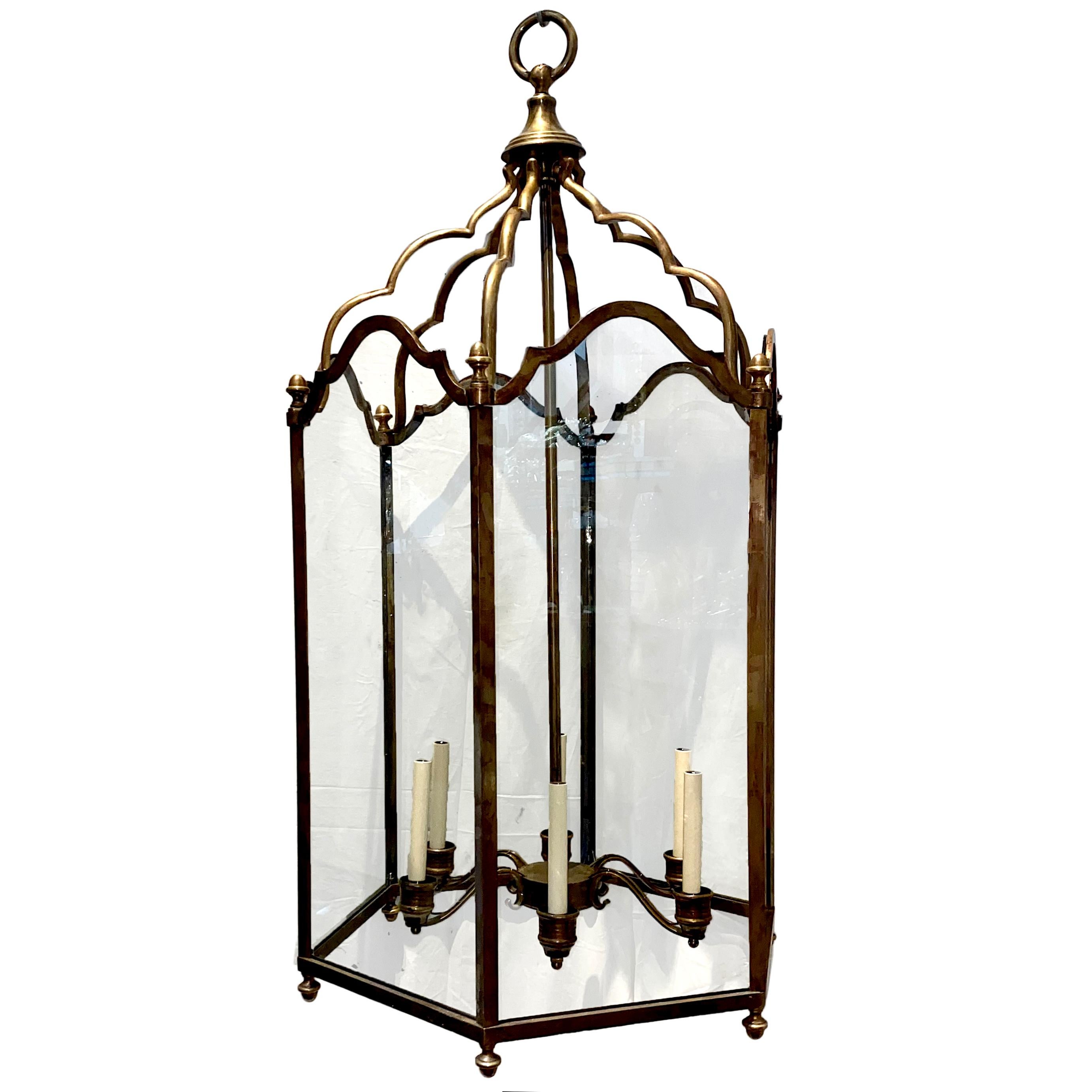 A circa 1940s English neoclassic style patinated bronze lantern with glass panels and six interior candelabra lights.

Measurements:
Present drop 51
