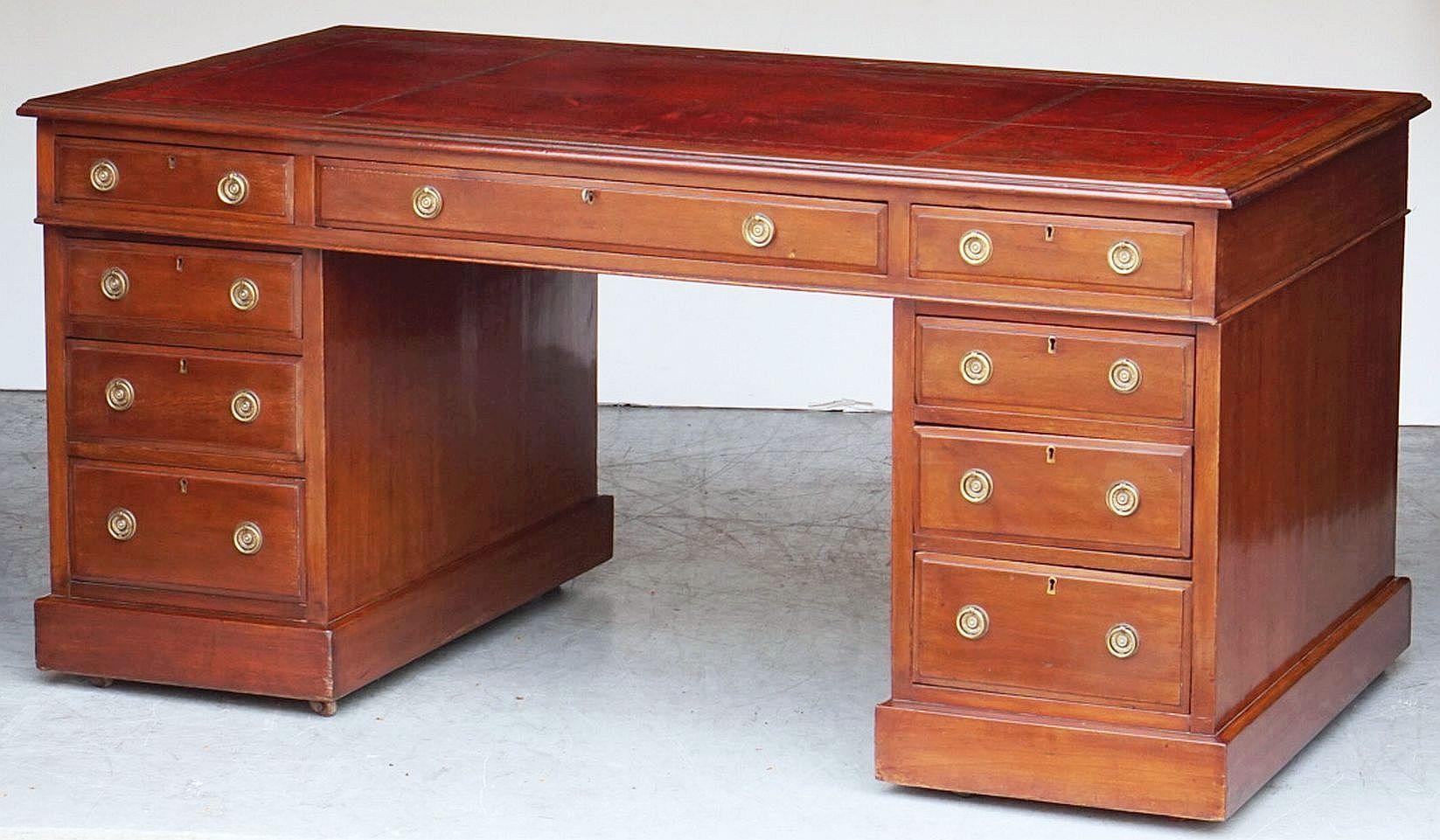 A handsome large English pedestal desk of mahogany, featuring a moulded top inset with an embossed leather, over a frieze with one long drawer flanked by two short drawers.
Resting on two pedestals, each with three short drawers on raised plinths