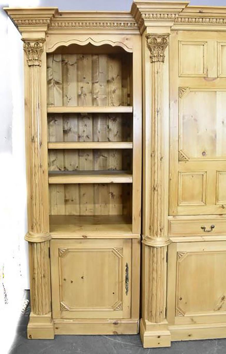 This large bookcase or display cabinet from England is impressive in person, beautifully carved cornice with wave carvings in the frieze. It is built in three sections allowing for easier installation. This piece has adjustable shelves inside