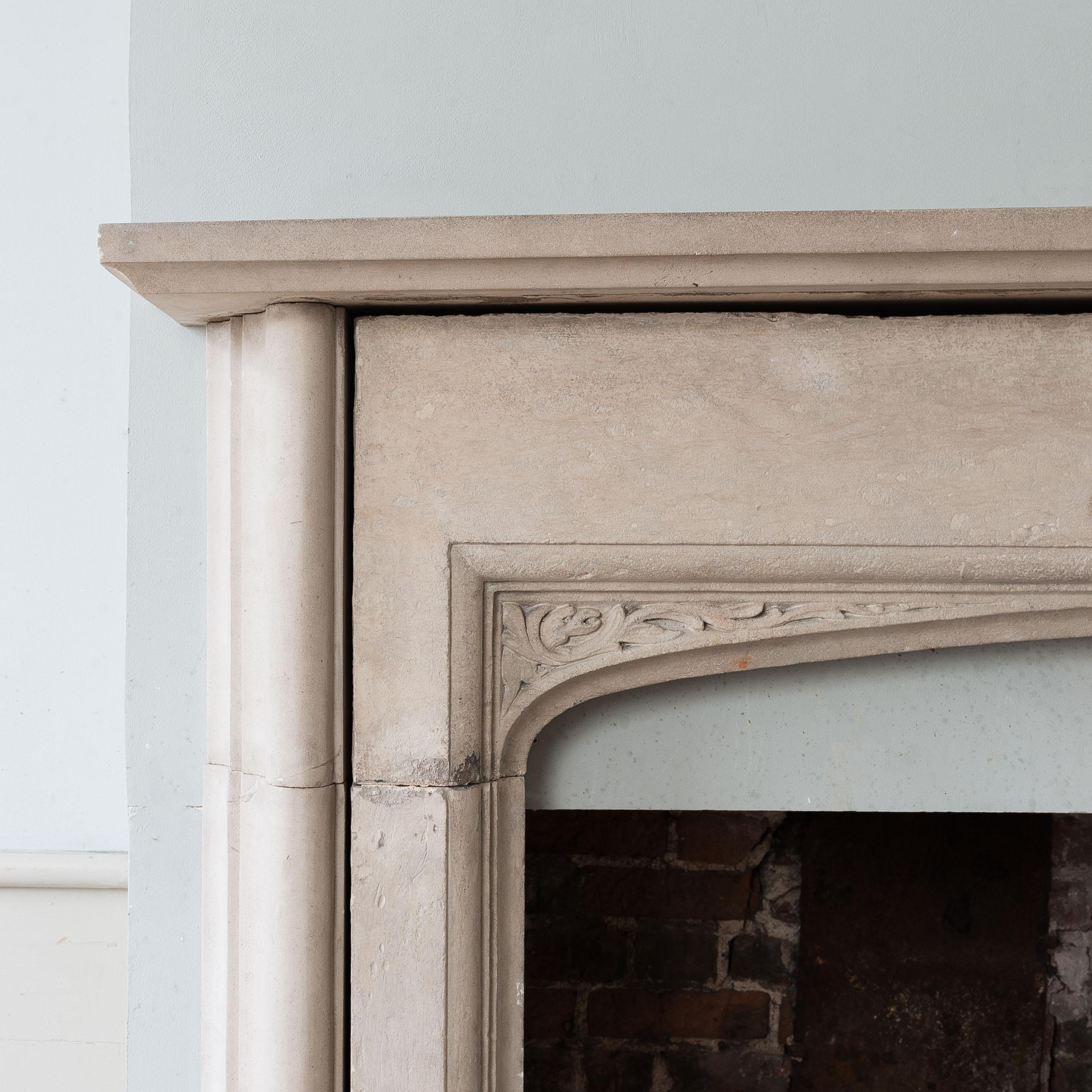 A large English Portland stone fireplace in the manner of Sir Edwin Lutyens, the rectangular shelf above bolection moulded jambs, the interior composed of Tudor arch with stop-chamfered ingrounds. Twentieth century, incorporating earlier