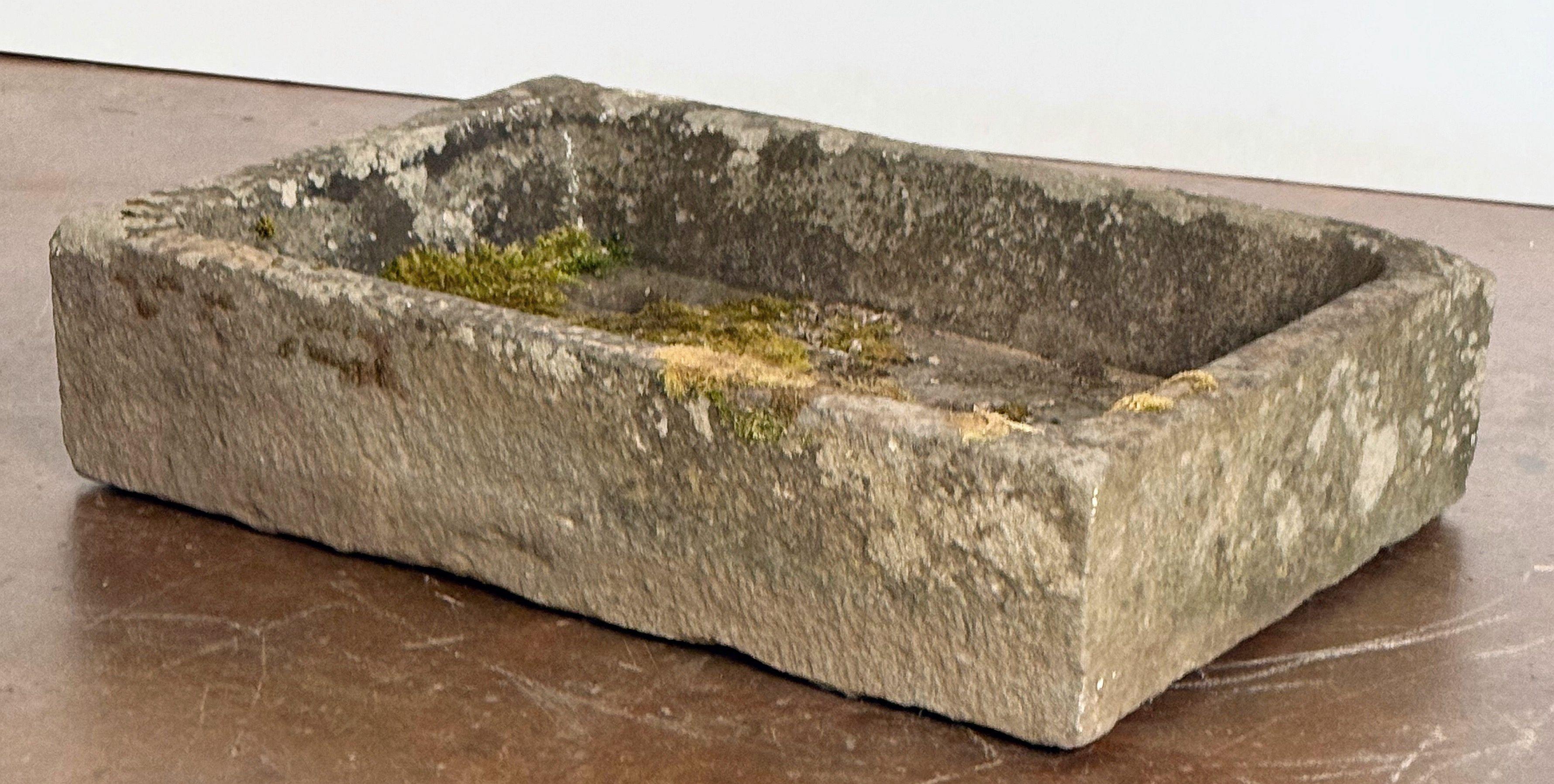 A finely worked English garden sink or trough of cut stone from the Georgian period, featuring a walled rectangular body with a hole in the base to one corner - perfect for use as a water feature or for planting.
 
Overall Dimensions: H 7 inches x W