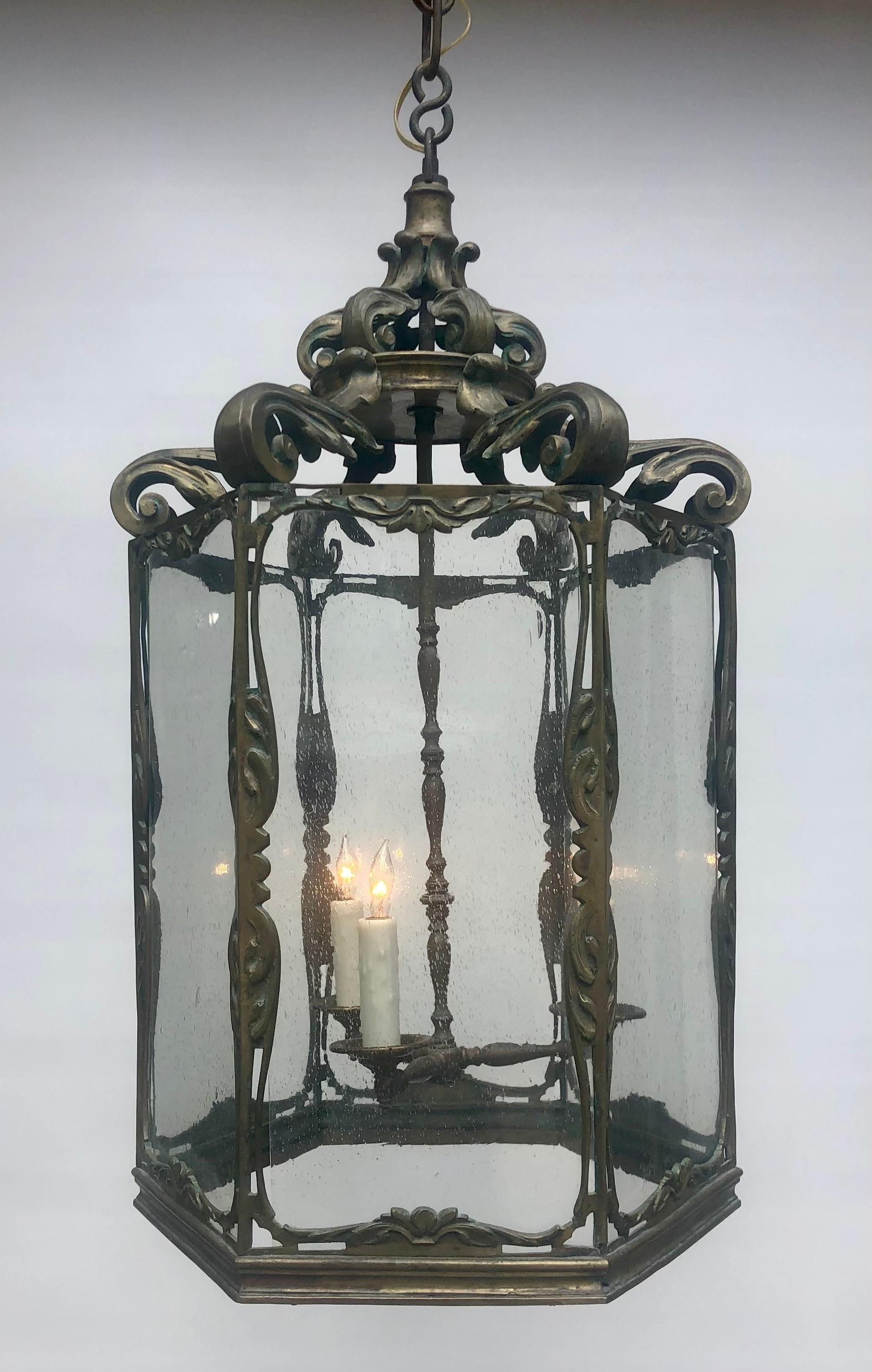 This Sophisticated English Regency Bronze Chinoiserie Hexagon Lantern with a three light cluster was made in the early 19th century. The Chinoiserie Bronze Lantern has six seed glass pane quadrants separated with bronze columns adorned with