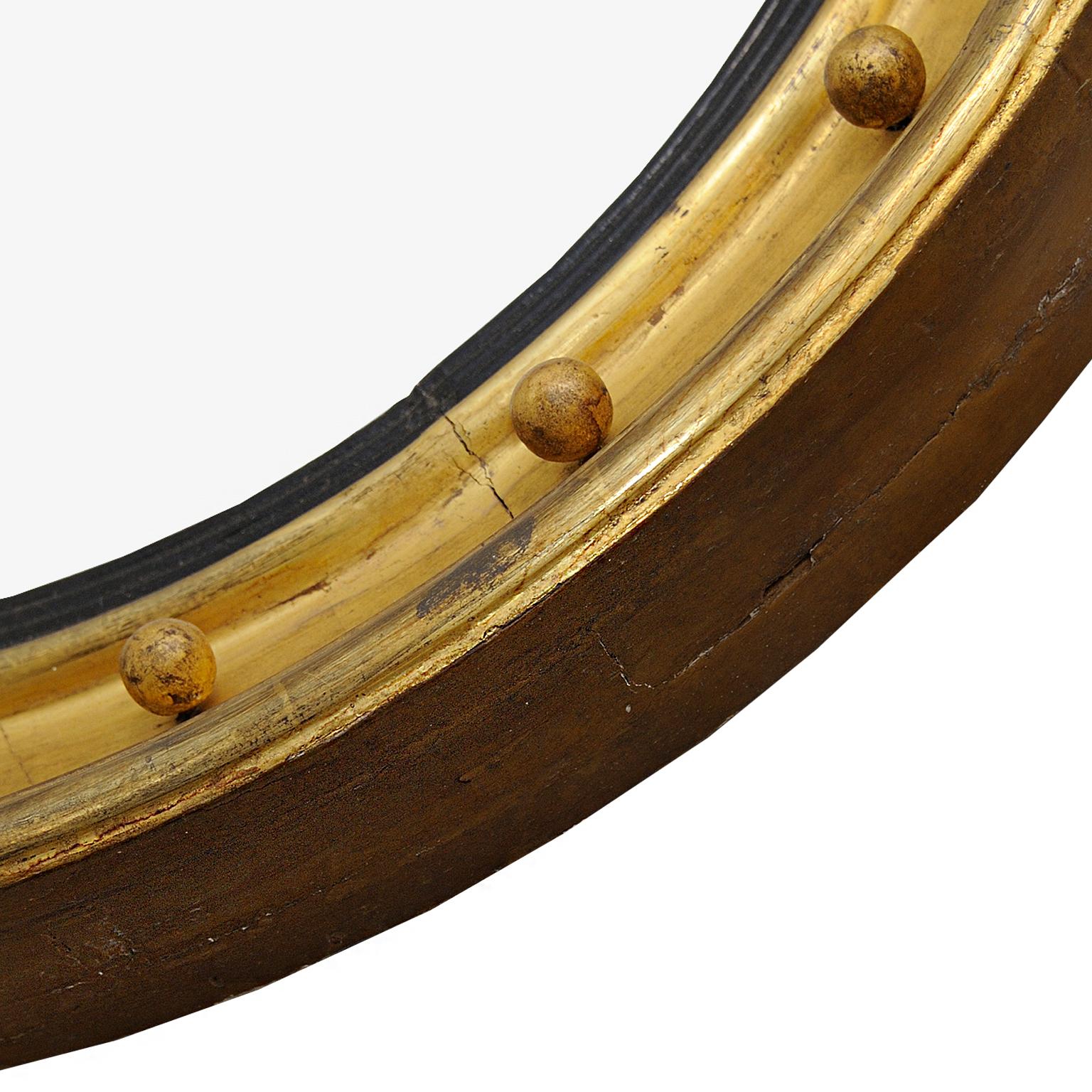 This is a large and stylish early 19th century English Regency giltwood convex mirror with original mirror plate and back boards, circa 1810.