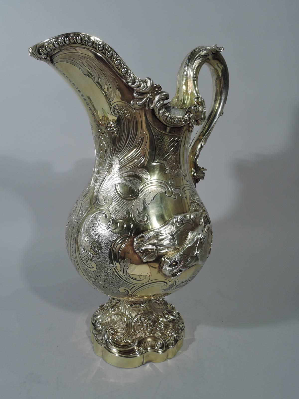 William IV gilt sterling silver ewer. Made by Robert Garrard II in London in 1833. Baluster with helmet mouth, leaf-capped high-looping, and raised foot with scrolled rim. Allover sumptuous with chased, cast, and engraved ornament. On one side in