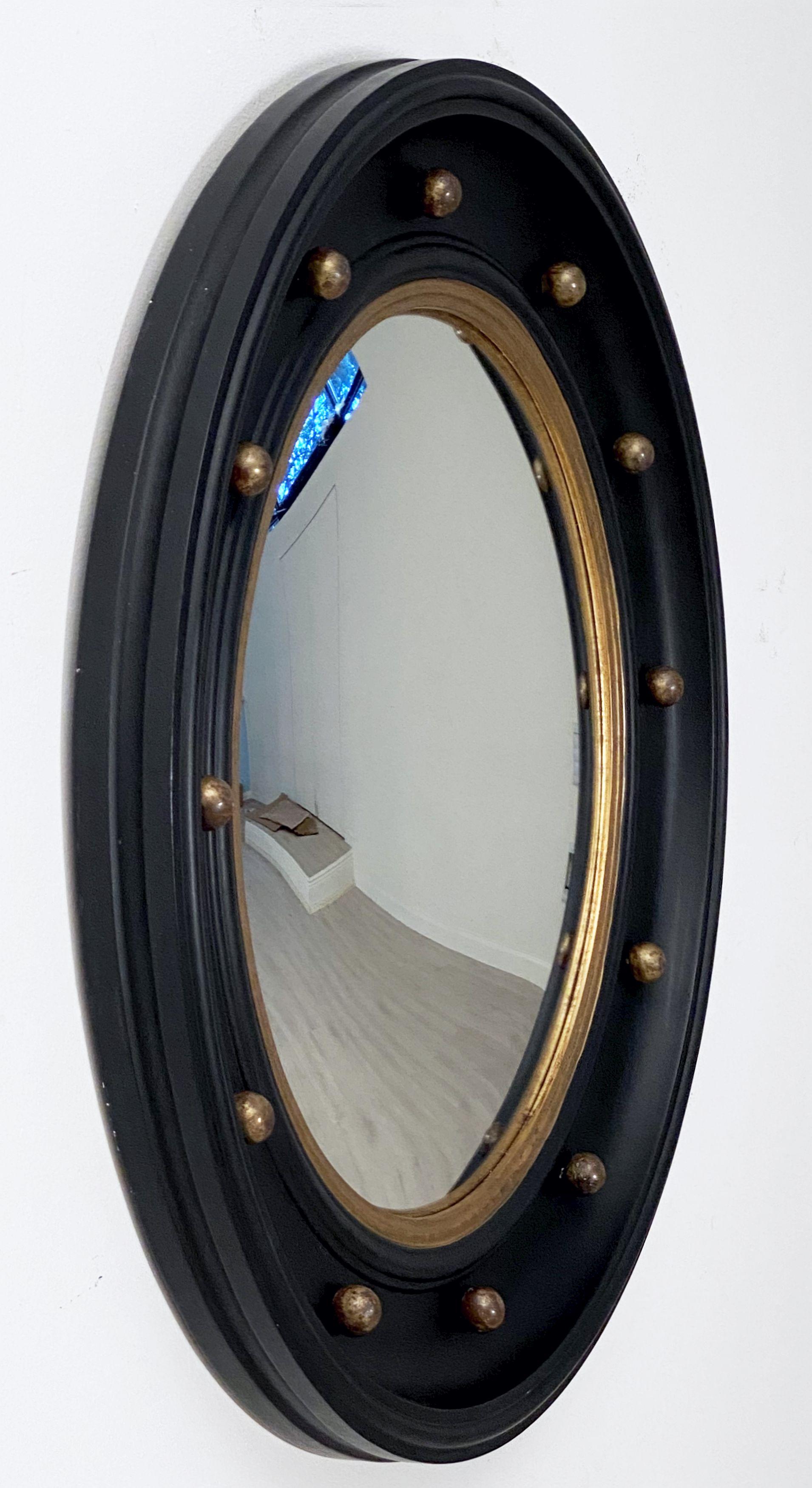 A fine very large English round or circular convex mirror featuring a Regency design of a molded, ebonized frame with gilt balls around the circumference.

Measures: Diameter is 29 inches
