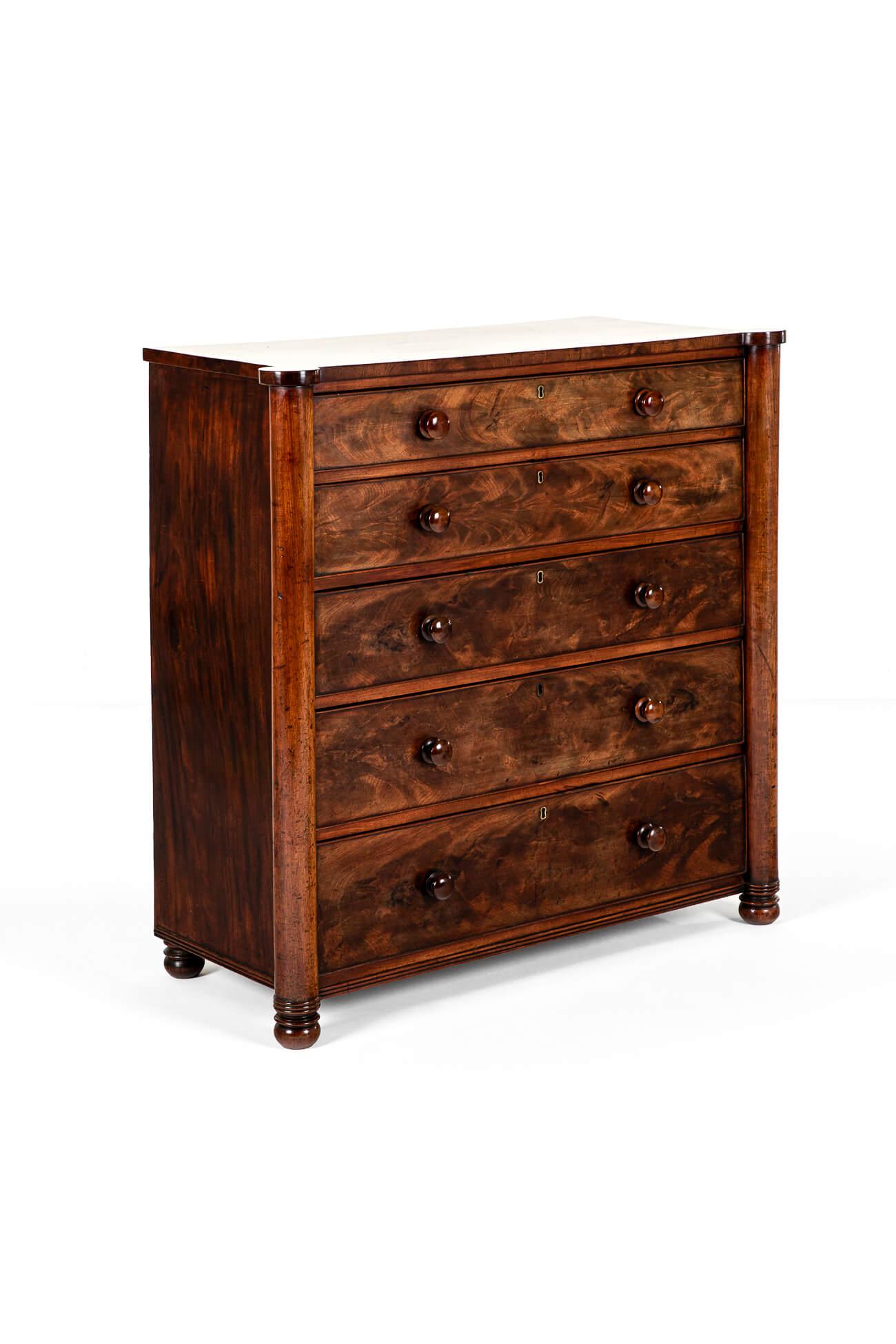 A regal Scottish mahogany rectangular chest of drawers of large stature containing five long smooth running drawers.

The thick mahogany top is flanked by two projecting turned columns resting on short turned feet.

Splendid colour and grain with