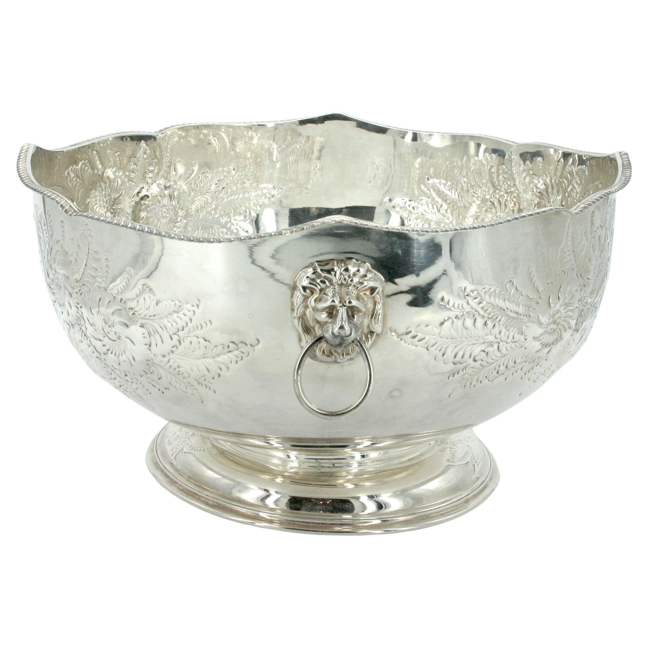 Large English Sheffield silver plate barware/tableware centerpiece punch bowl in the victorian style . The punch bowl features intricate exterior floral design resting on a round base in elegant proportions with Lion Head side handle . Great
