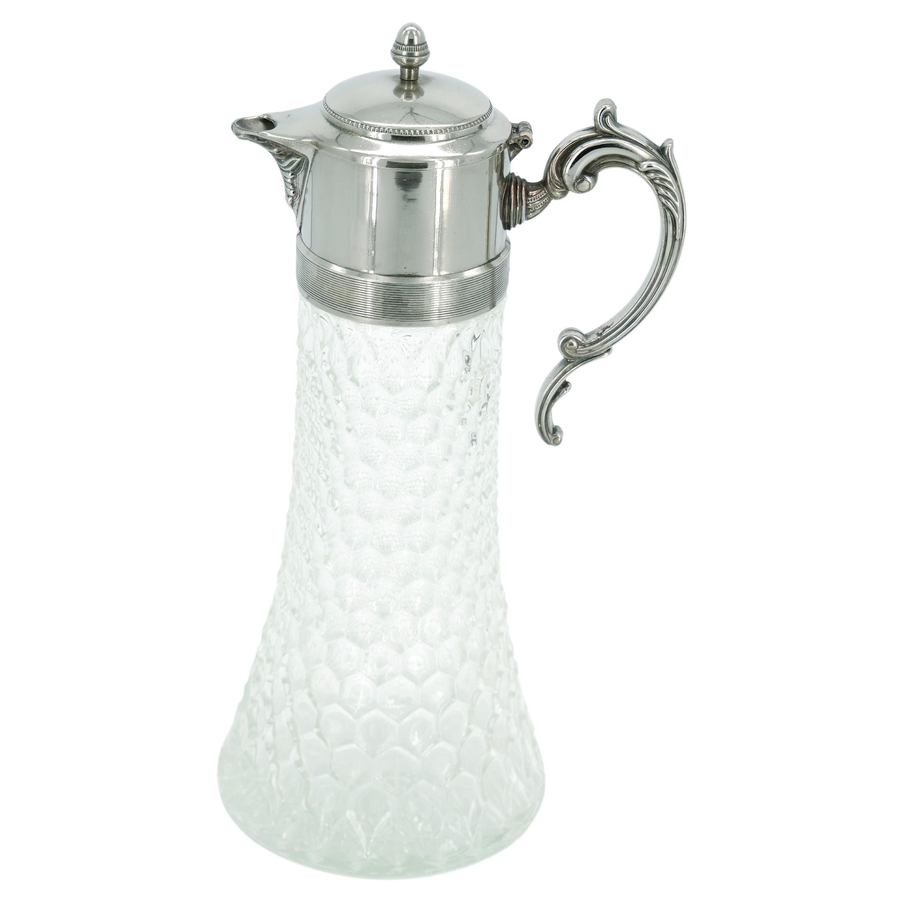 Introduce a touch of 19th-century elegance to your table or bar with this exquisite English Silver Plate and Cut Glass Claret Jug from the mid-19th century. The pitcher, designed in the Edwardian style, boasts a diamond-cut glass body, creating a