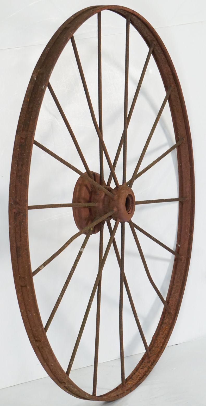 A handsome large English spoked cart or wagon wheel (54 inches diameter) of iron from the late 19th century, with 18 spokes around the wheel hub.

A nice feature for a garden or patio!