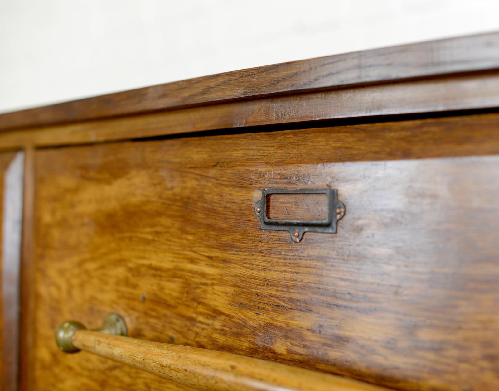 Large English tailors drawers, circa 1920s

- Oak frame, top and drawers
- Bevelled drawer fronts with dovetail joints
- Oak bar handles
- Copper card holders
- Originally used in a mens tailors in London and would have house rolls of cloth
-