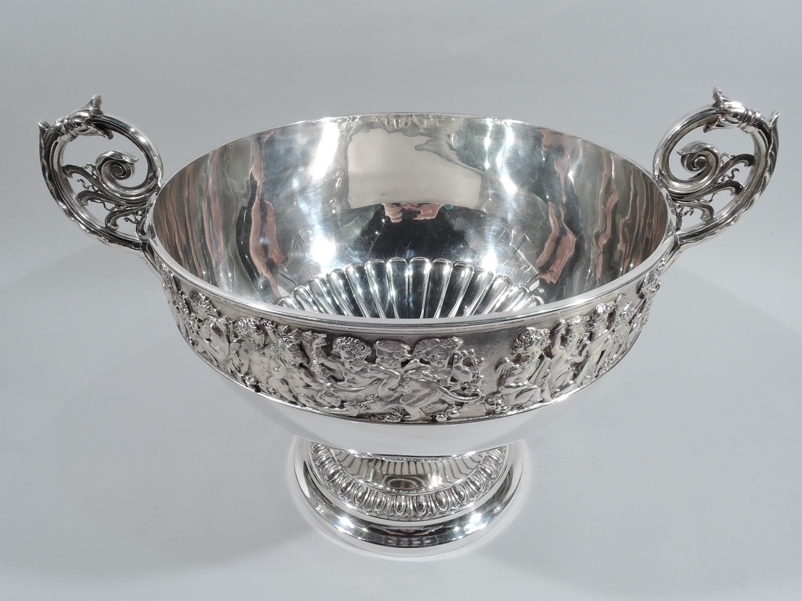 Victorian sterling silver bowl. Made by Elkington & Co. Ltd in Birmingham in 1896. Round and tapering with crowded cherubic frieze: Harp strummers, pipe blowers, and tambourine janglers with a few grape gorgers and goat huggers mixed in. A