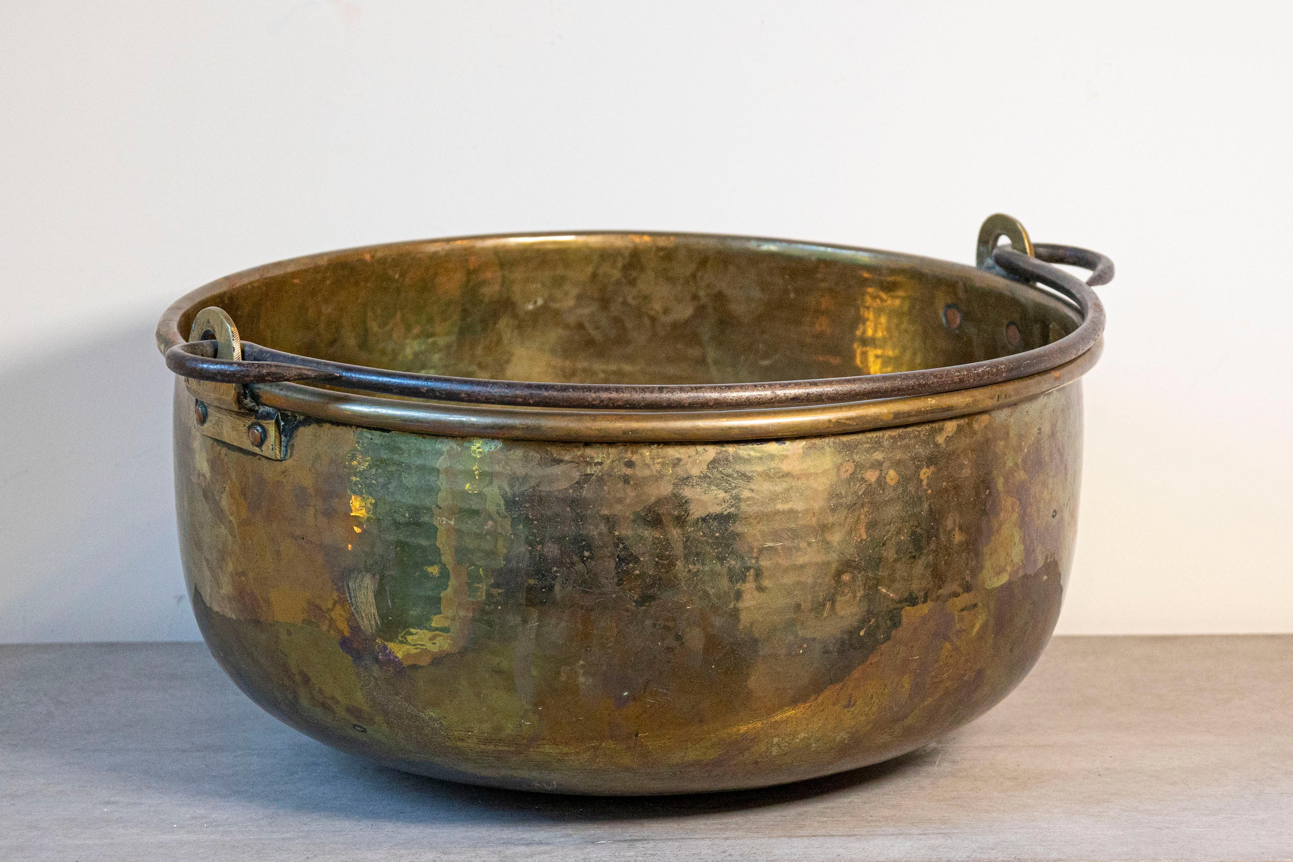 Un grande vaso inglese di epoca vittoriana in ottone della fine del XIX secolo, con maniglia. Creato in Inghilterra durante il regno della Regina Vittoria, questo vaso in ottone presenta un corpo circolare con effetti martellati, sormontato da un