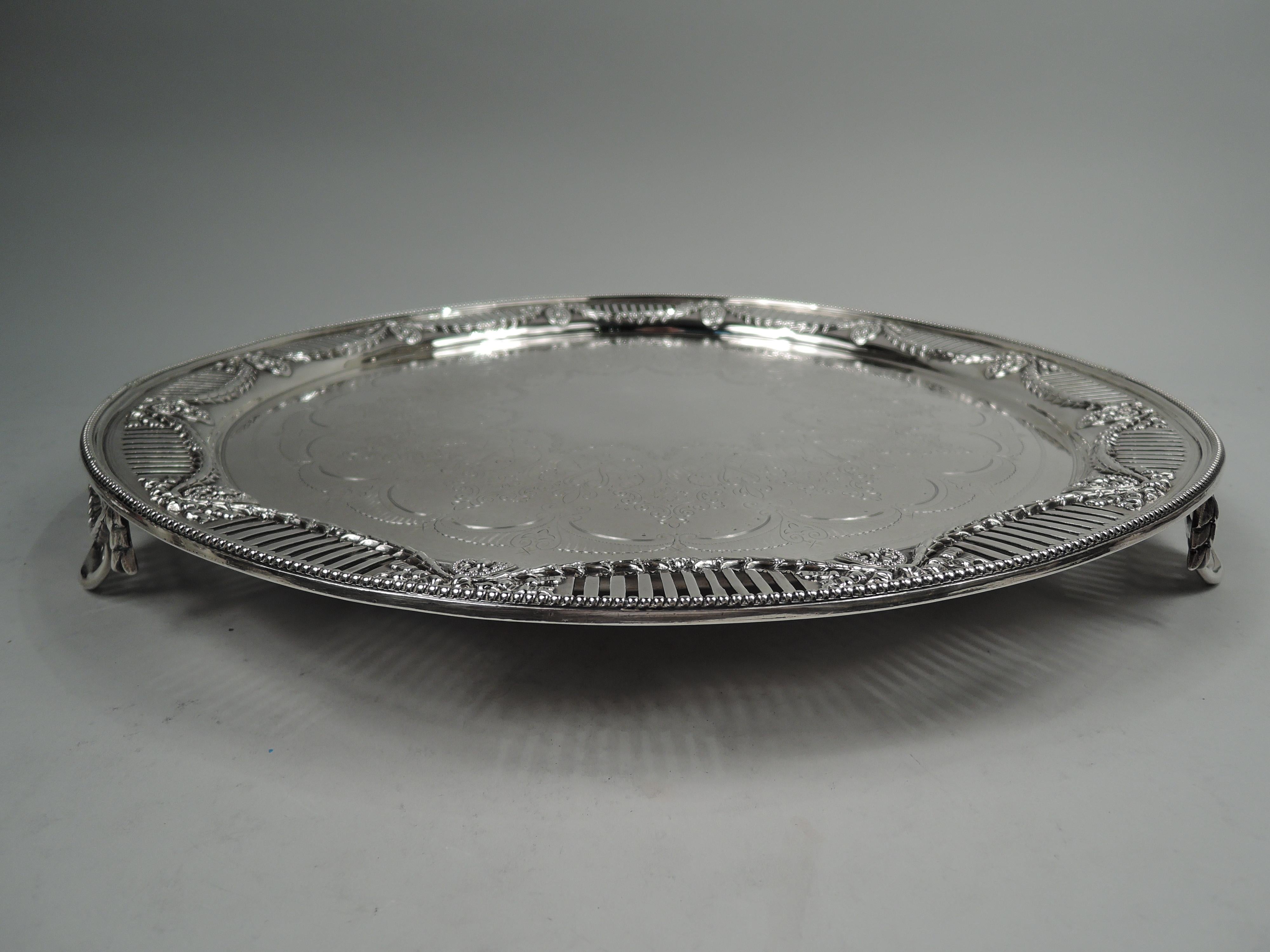 Victorian Regency Classical sterling silver salver. Made by John Aldwinckle and James Slater in London in 1880. Round and solid well engraved with stylized garland frame (vacant) in ornamental surround. Shoulder has applied ribbon-tied garland with