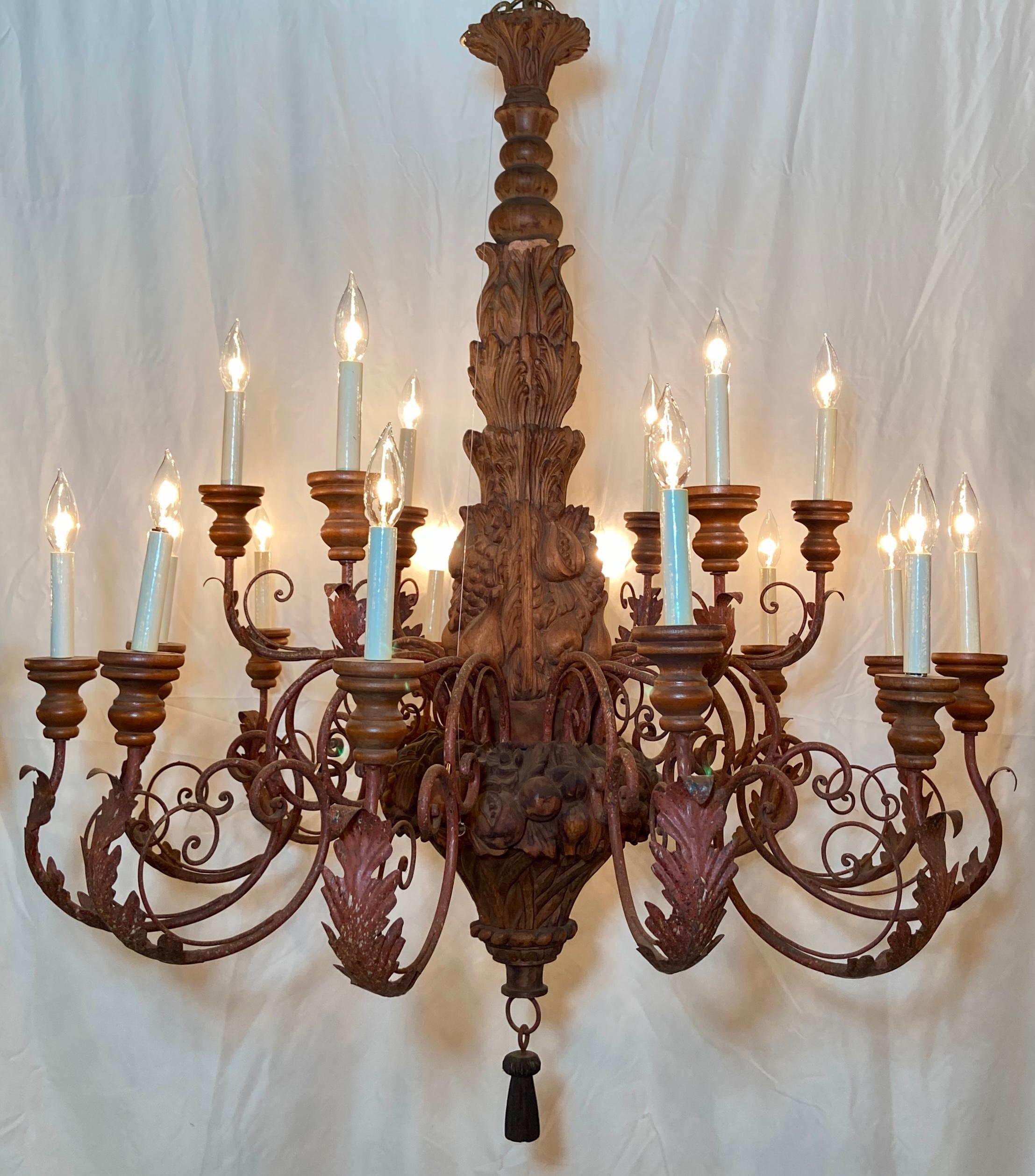 Large estate hand-carved wood and wrought iron 18-light chandelier.
Hand-carved with fruit, grape bunches and leaves.