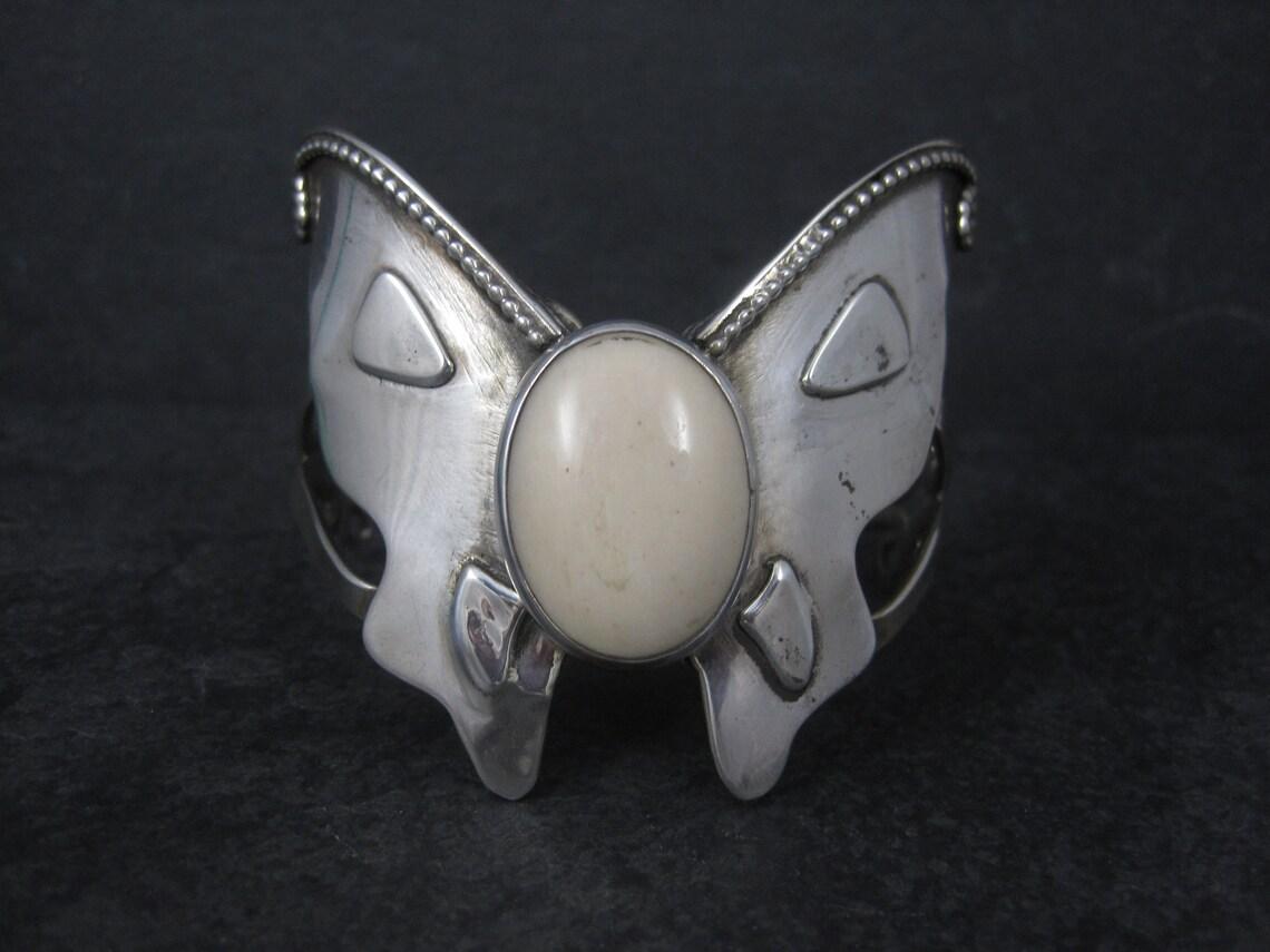 This gorgeous butterfly cuff bracelet is sterling silver with a 17x24mm oval agate stone.

The face of this cuff measures 2 5/16 inches wide.
It has an inner circumference of 6 inches including the 1 inch gap.
Weight: 38.3 grams

Marks: