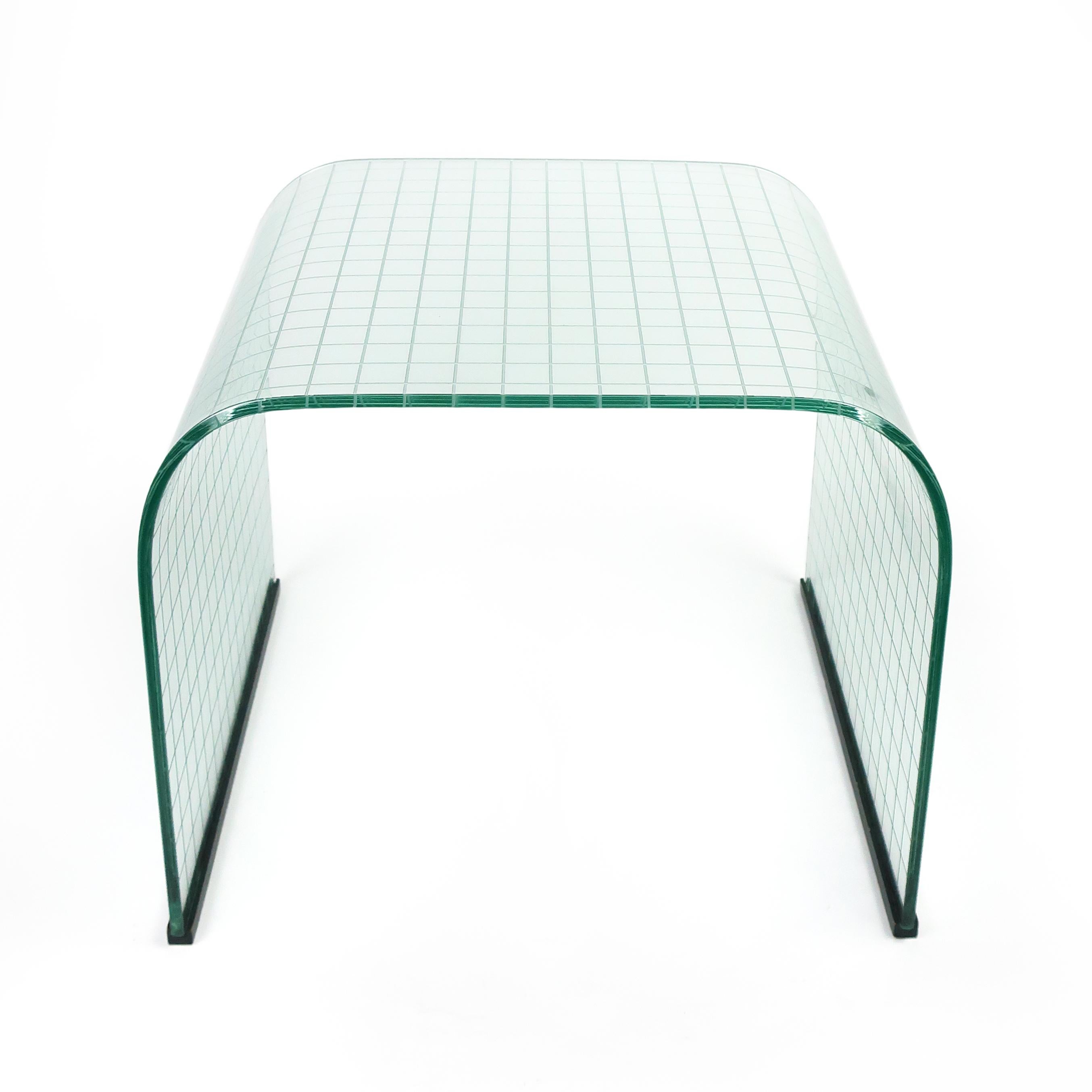 A large 1970s glass waterfall accent, nesting, or bedside table designed by Italian designer and architect Angelo Cortesi for FIAM of Italy. Has an etched grid pattern on its underside. Distributed by Pace in the 1970s and made of tempered glass.