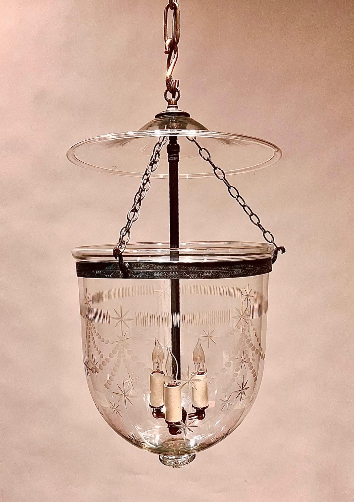 This large hand-blown & etched bell jar lantern is a real beauty. It has 8 point stars, fine reeded detail, and a swag border. The lantern has a fine patina with the minor differences that are typical of real hand-done work. We have electrified it