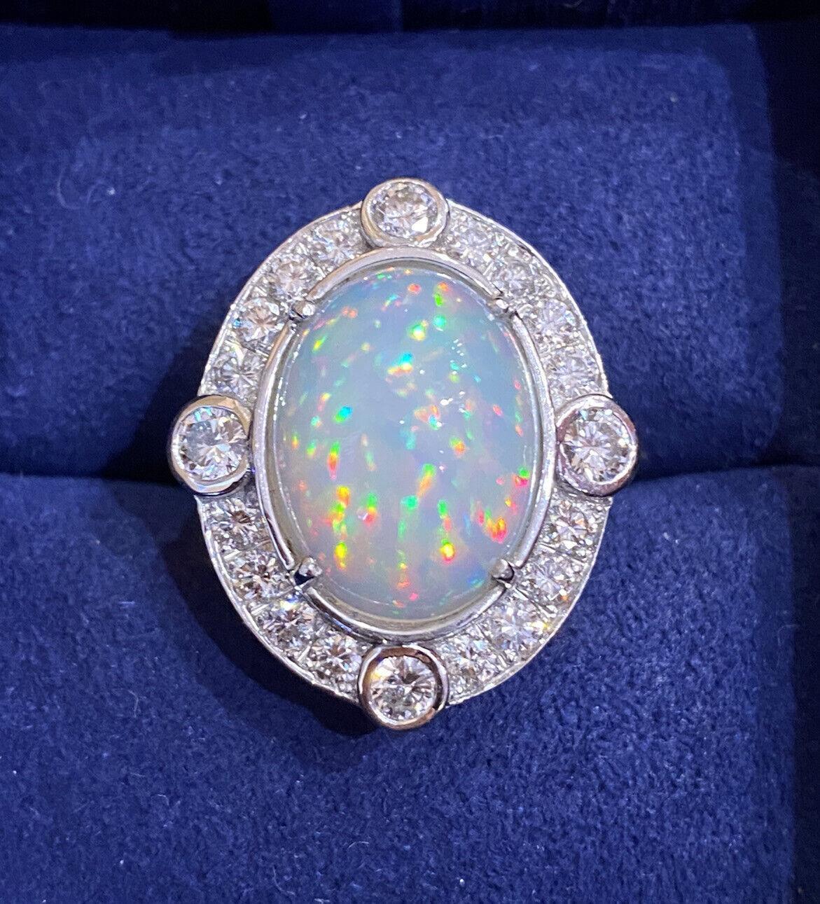 Large Ethiopian Opal Vintage Diamond Ring in 18k White Gold

Vintage Opal Diamond Ring features a large dome Oval-shaped Ethiopian Opal in the center with Flashes of Green, Orange, and Yellow accented by 20 Round Brilliant Diamonds set in 18k White