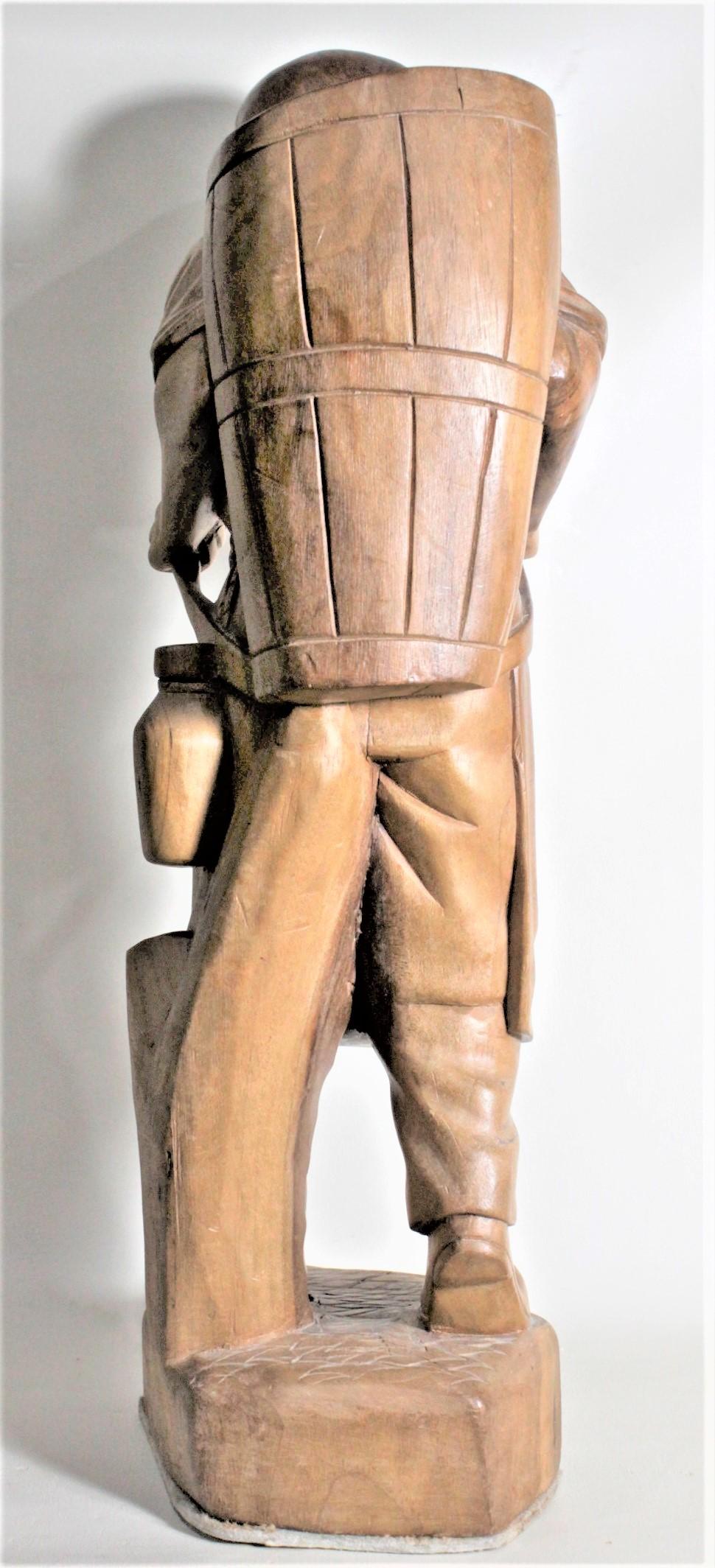Sculpté à la main Grand homme debout en bois sculpté d'art populaire européen portant une sculpture en forme de panier en vente
