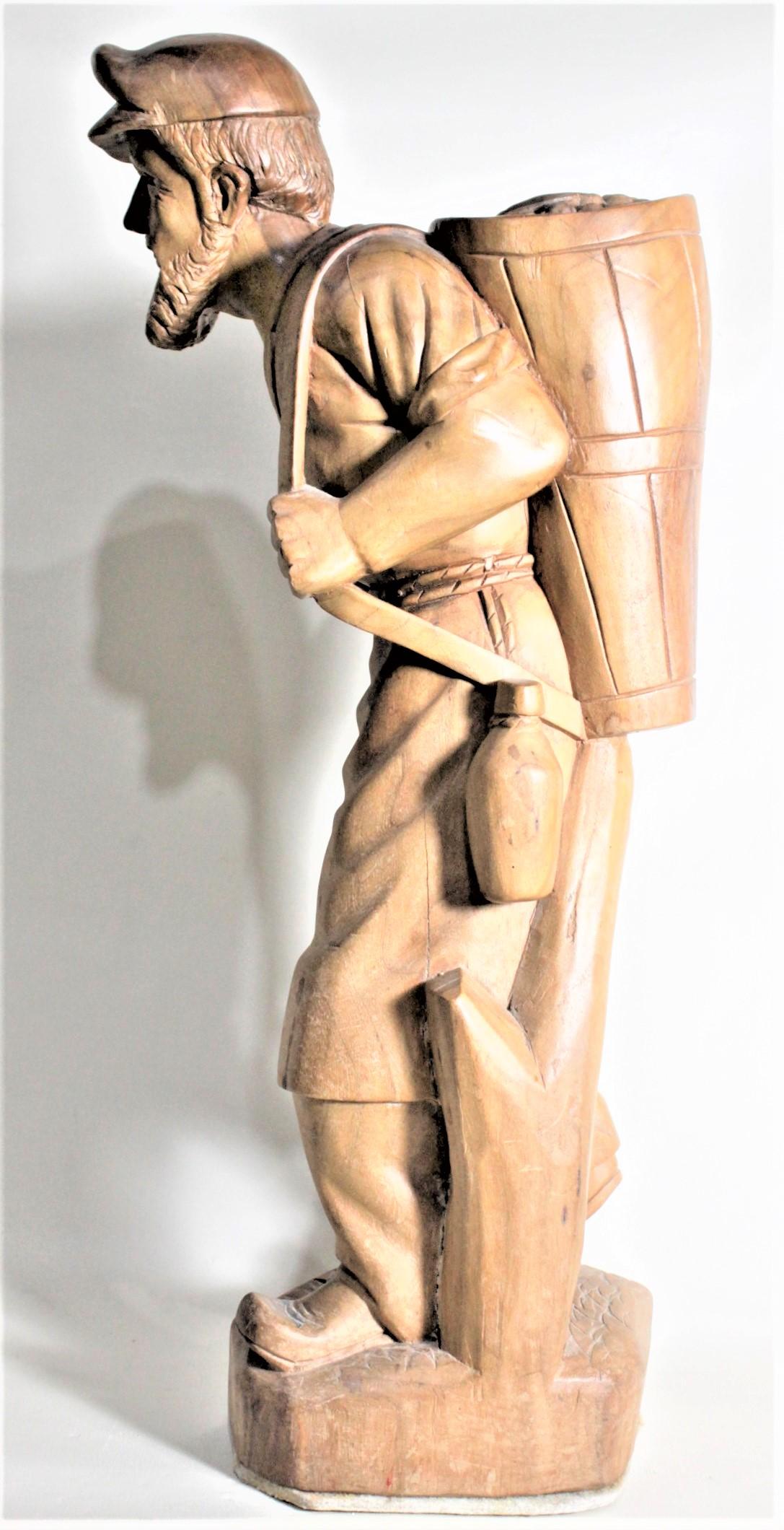 Hand-Carved Large European Folk Art Carved Wooden Standing Man Carrying a Basket Sculpture For Sale