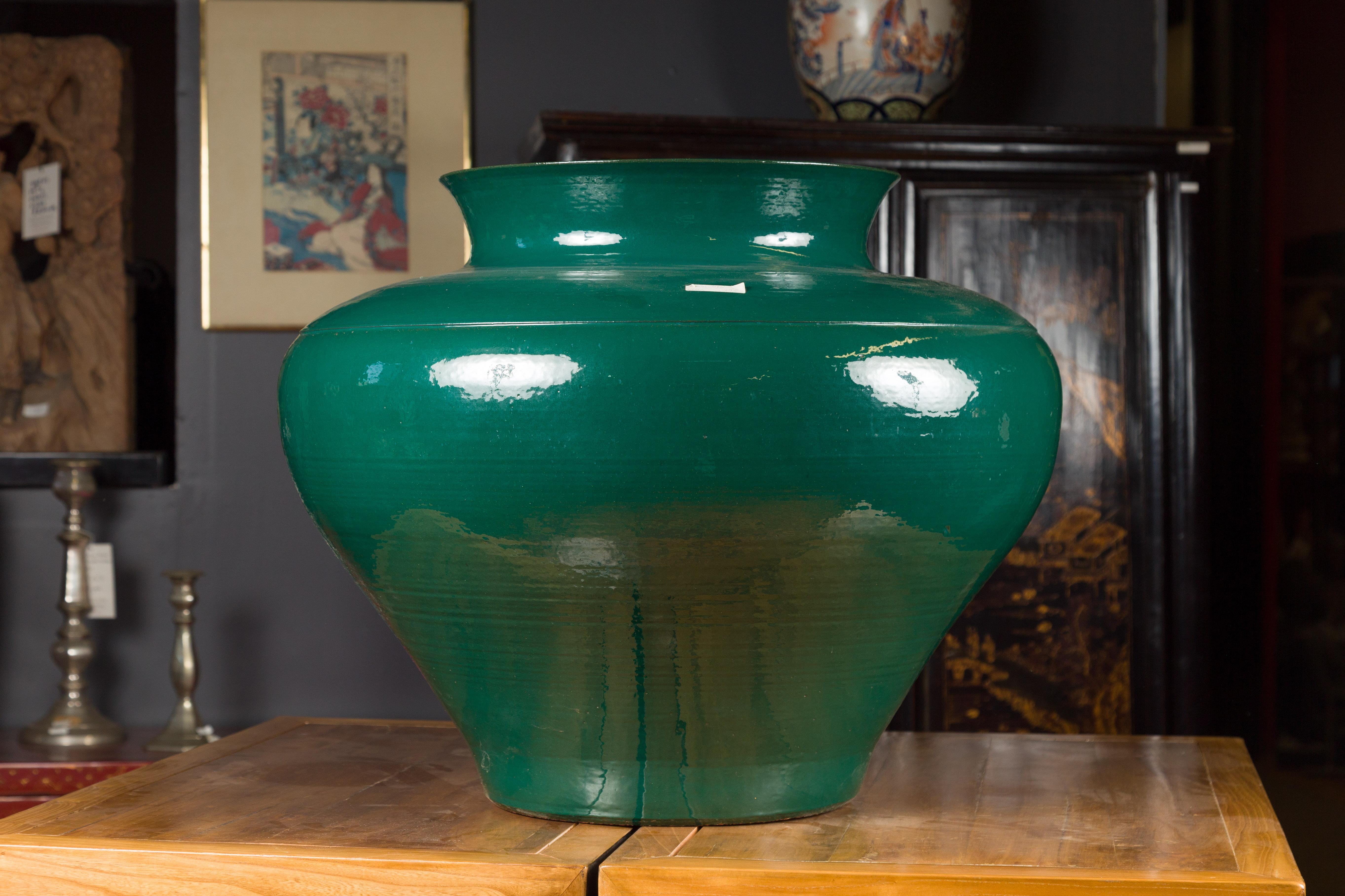 A large European green lidded urn from the late 20th century, signed Thomas W Hoff. Created in the later years of the 20th century, this large urn attracts our attention with its green finish and generous body. Made of contrasting lines delicately