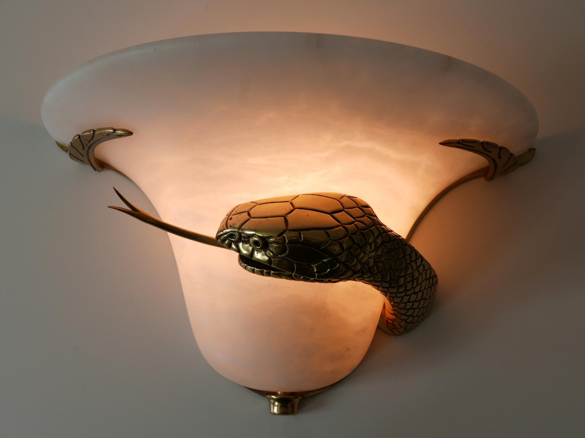 Extremely rare Mid-Century Modern cast brass and alabaster snake sconce or wall lamp. Designed and manufactured probably in Italy, 1970s.

Executed in cast brass and marble (alabaster), the lamp needs 1 E27 / E26 Edison screw fit bulb, is