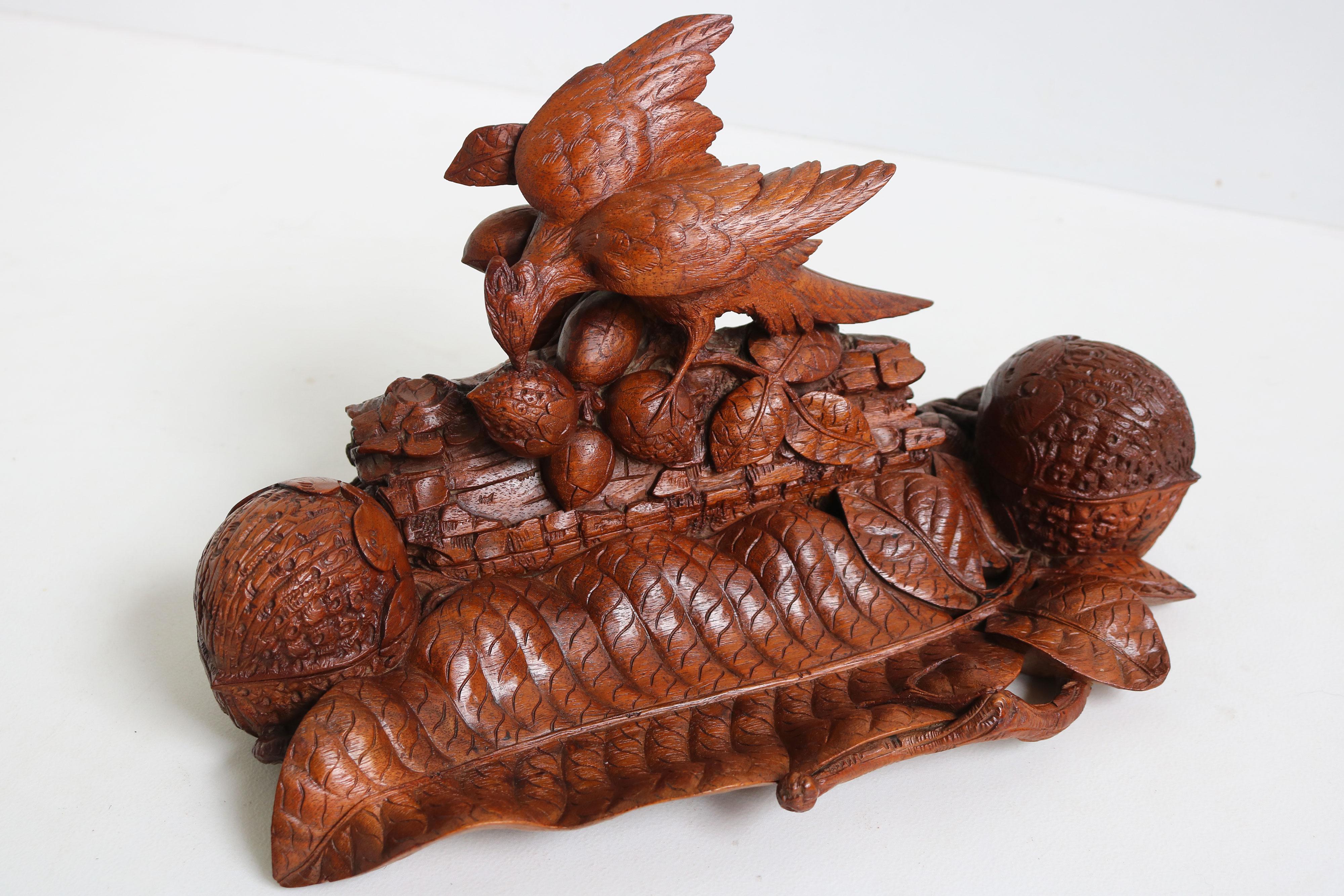 Magnifique et très rare encrier double / accessoire de bureau de la Forêt Noire suisse du 19e siècle, entièrement sculpté à la main, représentant un oiseau mangeant des noix et des feuilles florales / noix.
Sculpté par un maître sculpteur avec un