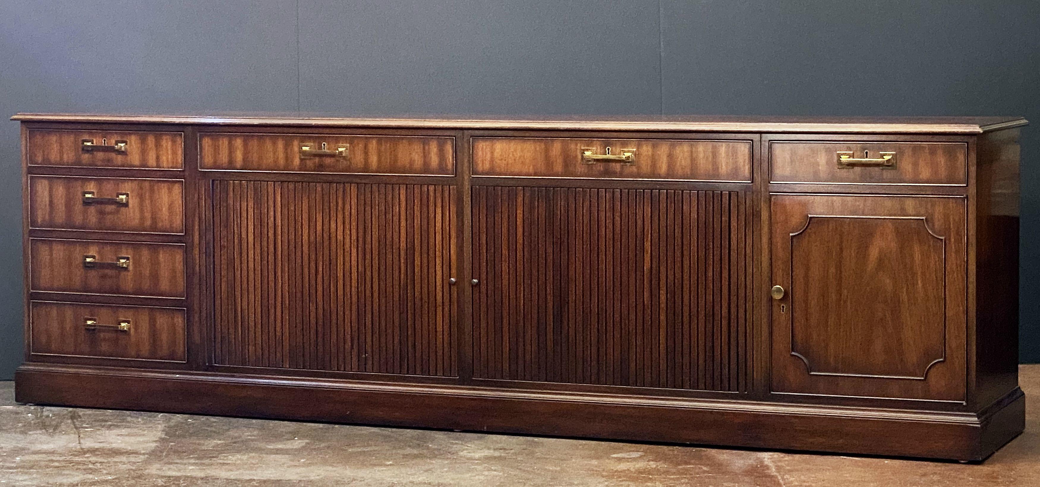 A fine large executive console table or storage cabinet, featuring a moulded wood top over a frieze of drawers and cabinets, with sliding tambour doors in center, by Kittinger.

With metal Kittinger name plaque in drawer.

Dimensions: H 30 1/2