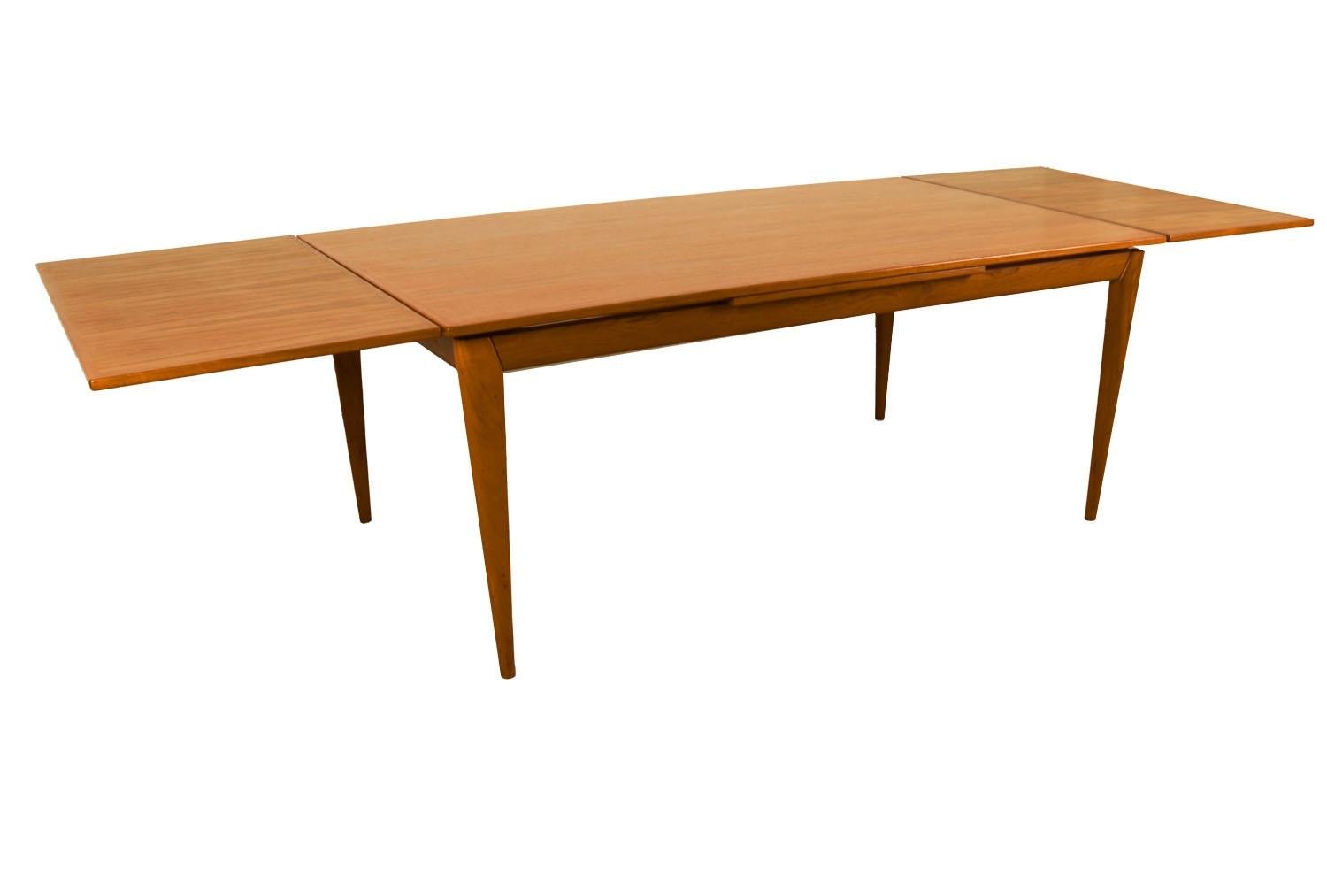 Ein außergewöhnlicher dänischer moderner Esstisch aus Teakholz, hergestellt in Dänemark. Mit seiner anfänglich großen Grundfläche kann dieser Tisch auch einen großzügigen Platz bieten und seine Größe verdoppeln, wenn seine versteckten Ausziehplatten