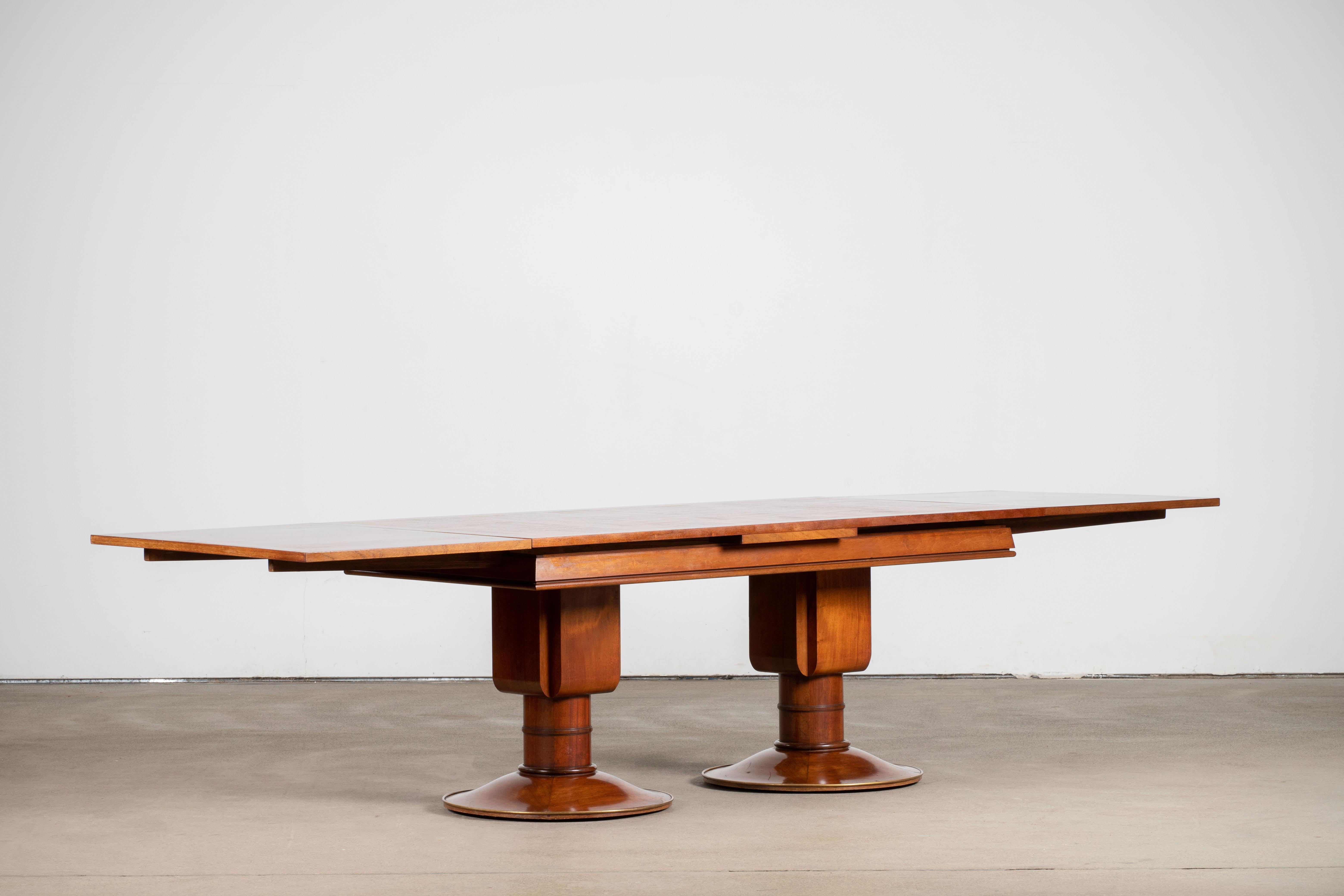 Art Deco table in Solid Mahogany resting on two pedestal legs, French work, 1930. 

Art Deco is a style of visual arts, architecture and design that first appeared in France just before World War I. 

It's combined modernist styles with fine