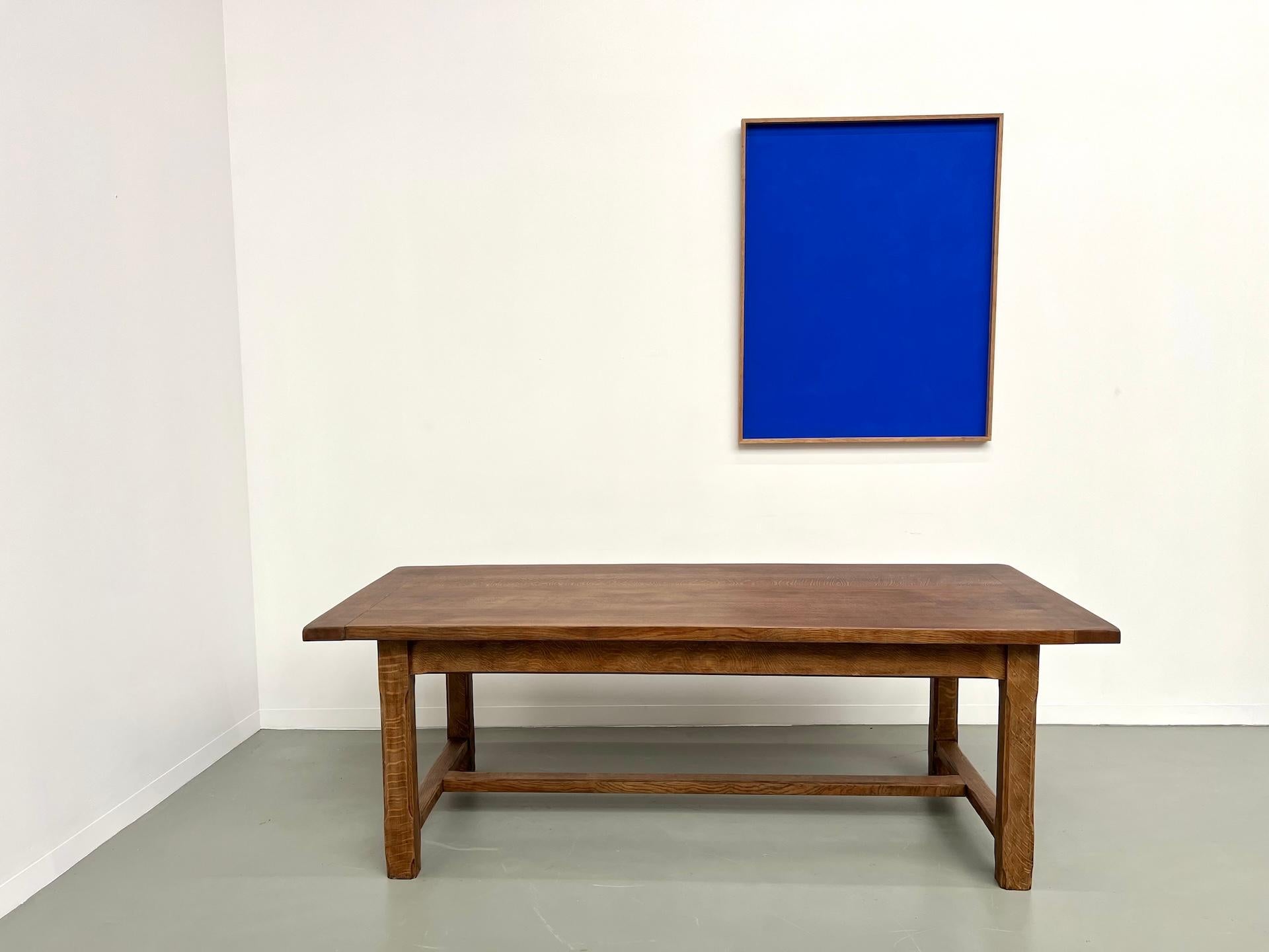 This large 1950s farmhouse table, fully restored by us, has it all. A perfect patina, solid oak with beautiful grain, quality joinery, and a thick top give the table exceptional durability and robustness. Offered here in a matte varnish finish, it