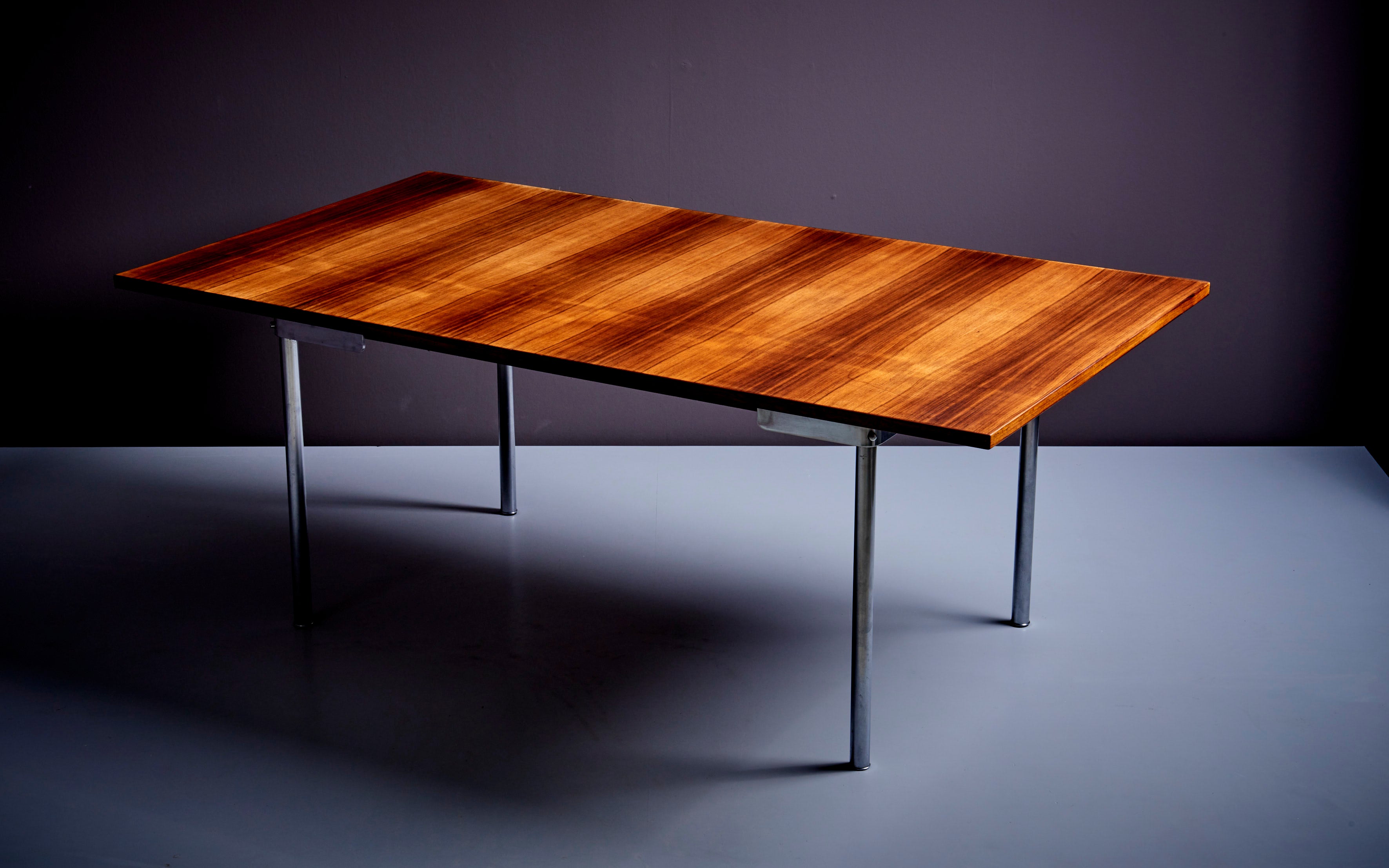 Large dining table designed by Hans Wegner and manufactured in Denmark. Beautiful Rosewood top and elegant base with chromed legs. The table can be extended up to a width of 260cm. 

Hans Wegner (1914-2007) was a Danish furniture designer who is