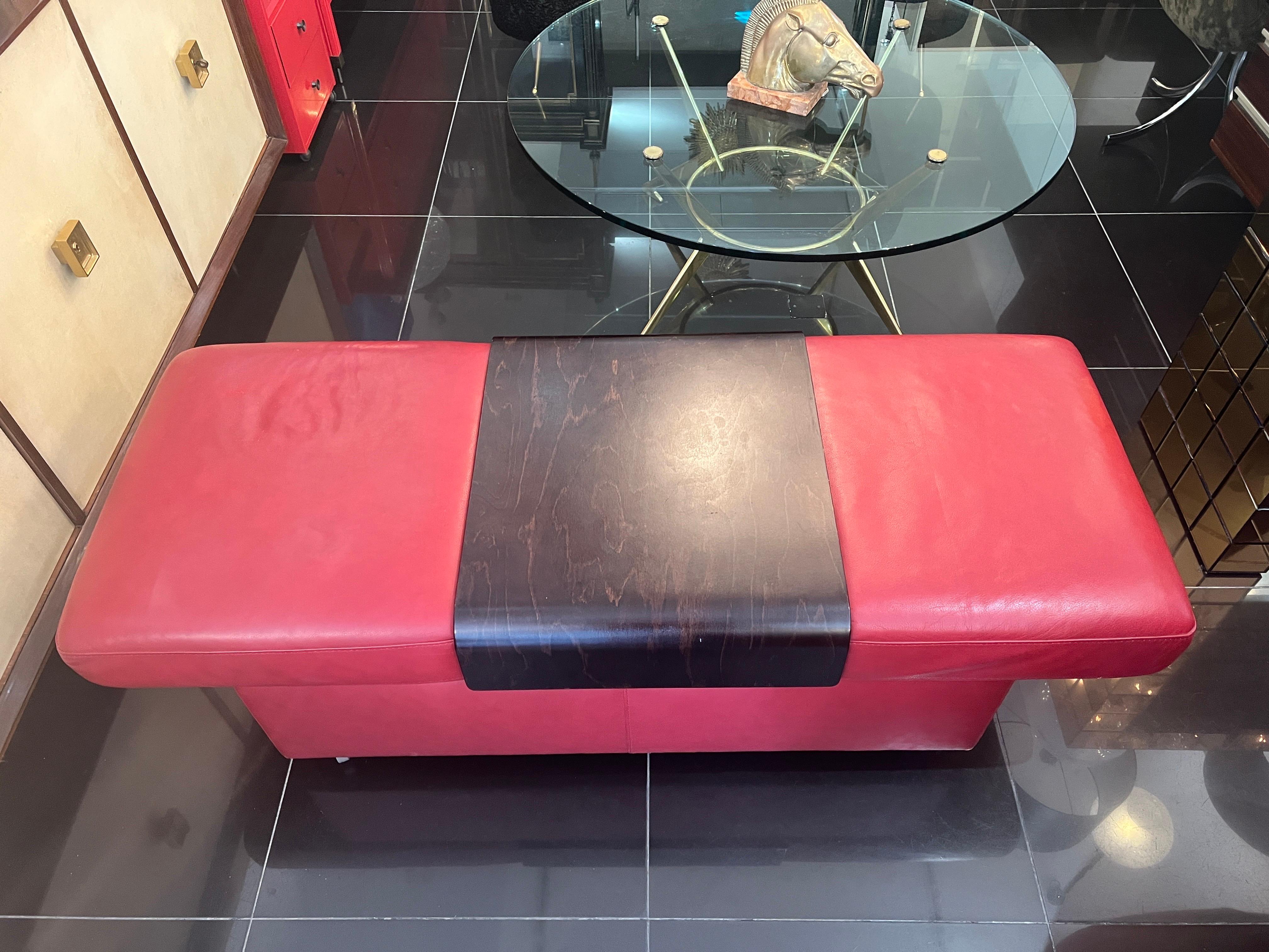 An exquisite extendable ottoman in fine red Italian nappa leather with an adjustable wood table top . The ottoman can open to reveal a good storage space on the inside which is fully lined in wood . The bentwood table top is removable and can be