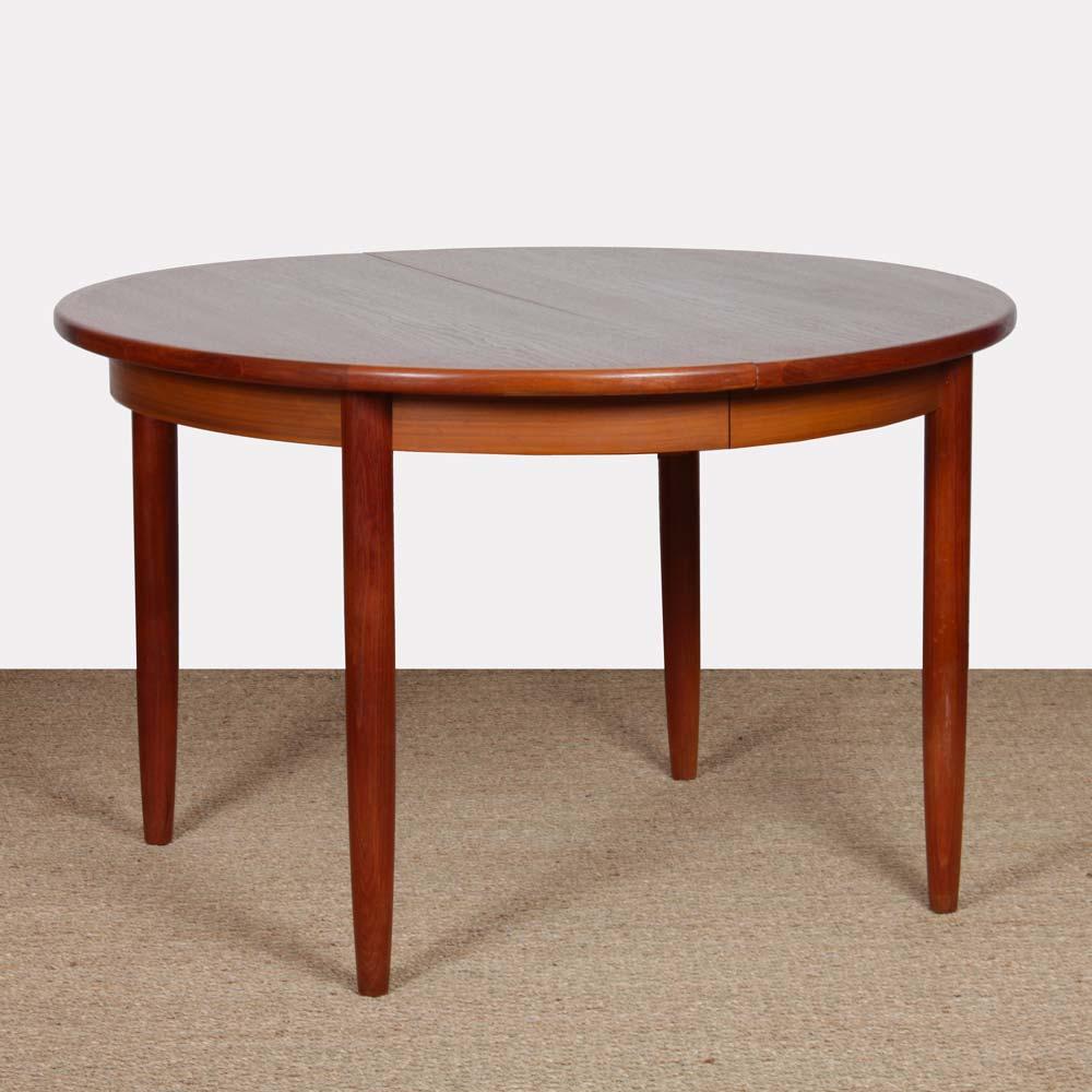 This large round teak dining table is extendable. It includes three extensions, each measuring 35 cm. It is a Scandinavian design from the 1960s. This table is in good vintage condition. The top has been restored.