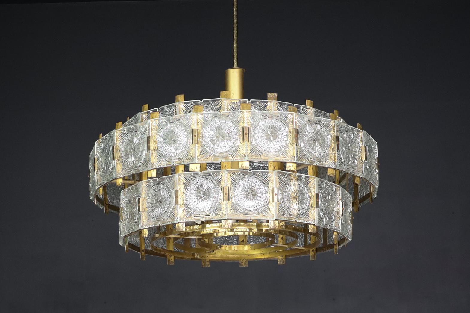Large extravagant chandelier with patinated brass fixture, Praque 1960s

Large luxurious chandelier with patinated brass fixture and thick decorative cut crystal glass elements produced and designed in Czechia in the 1960s. This chandelier with a