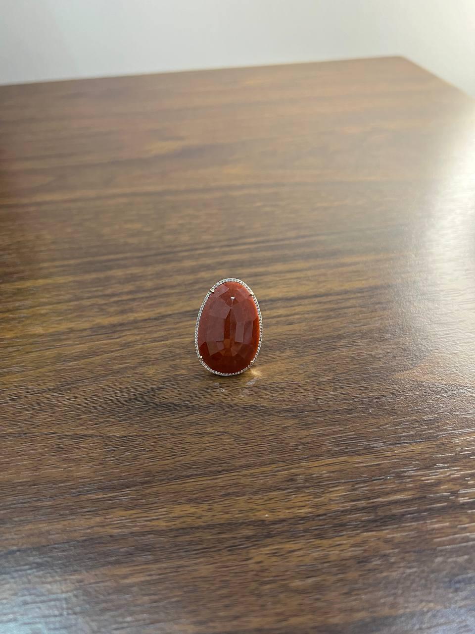 This striking ring captivates with its bold, faceted design.
Crafted in 14k gold, it showcases a rich, deep red jasper (54.69 carats) set in a simple yet elegant bezel, allowing the stone's natural beauty to shine.
The gemstone's teardrop shape is