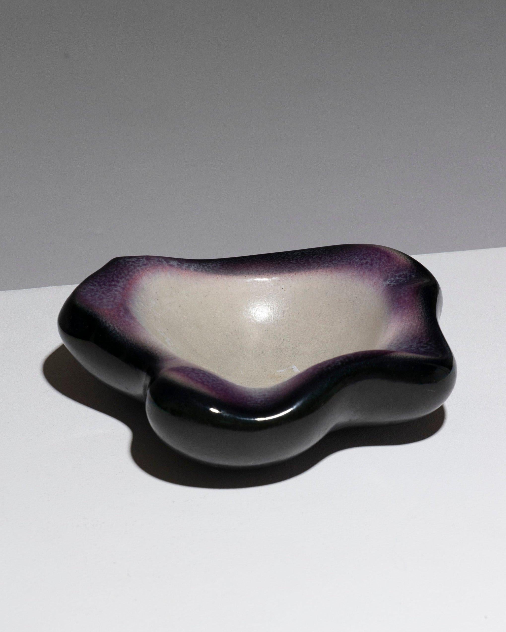 Raro cenicero o cuenco de barro de forma libre de Pol Chambost de la década de 1960. Esmaltes característicos de su obra: Sombreado Negro Y Rosa-Púrpura Alrededor Del Borde. La cuenca del cuenco es de color blanco lechoso brillante. Firma con