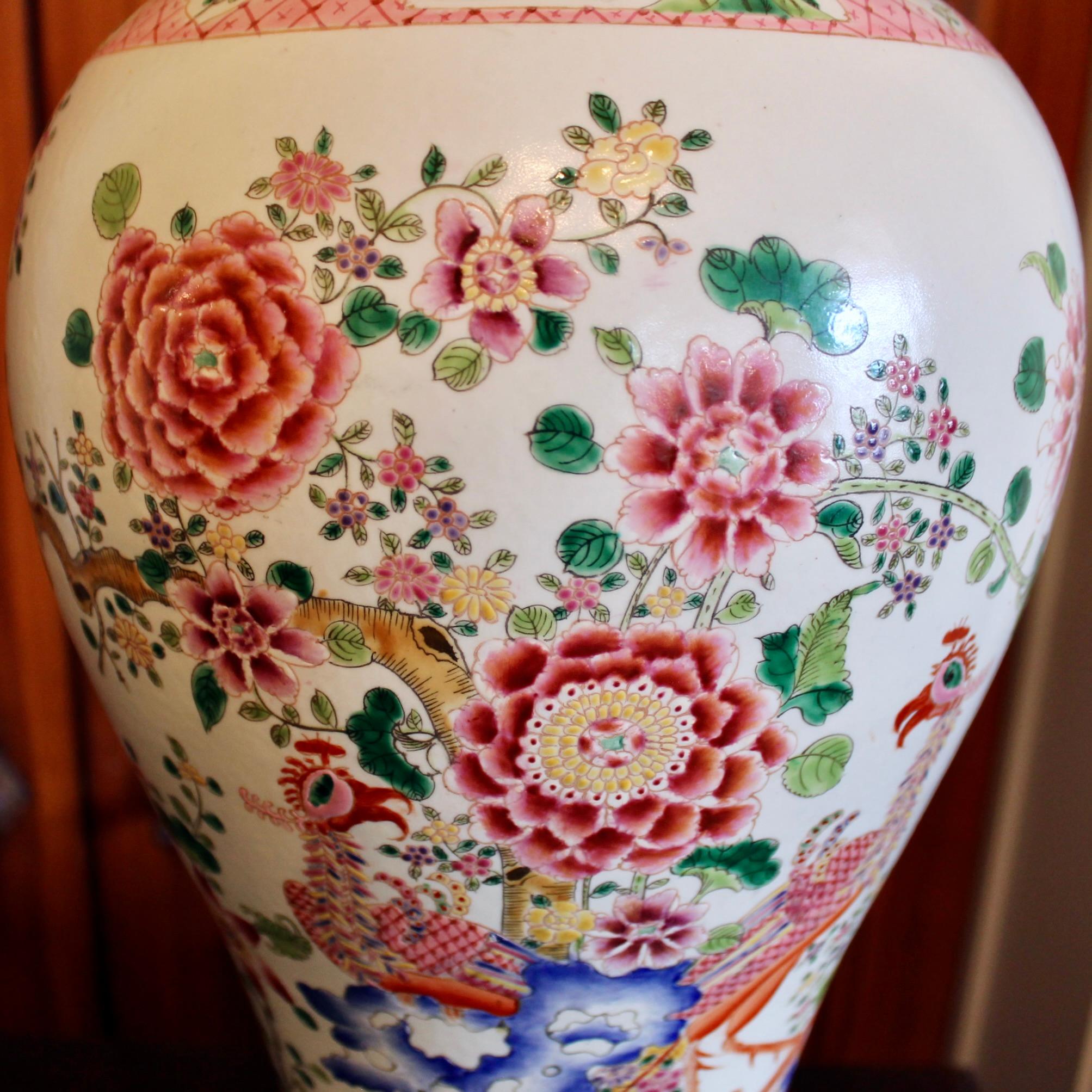 A large and very decorative Famille Rose porcelain jar featuring a traditional theme in Chinese porcelain, an idyllic garden with an ornamental fence and rockery, from which a flowering tree springs. Exotic birds perch within the scene. The tree is