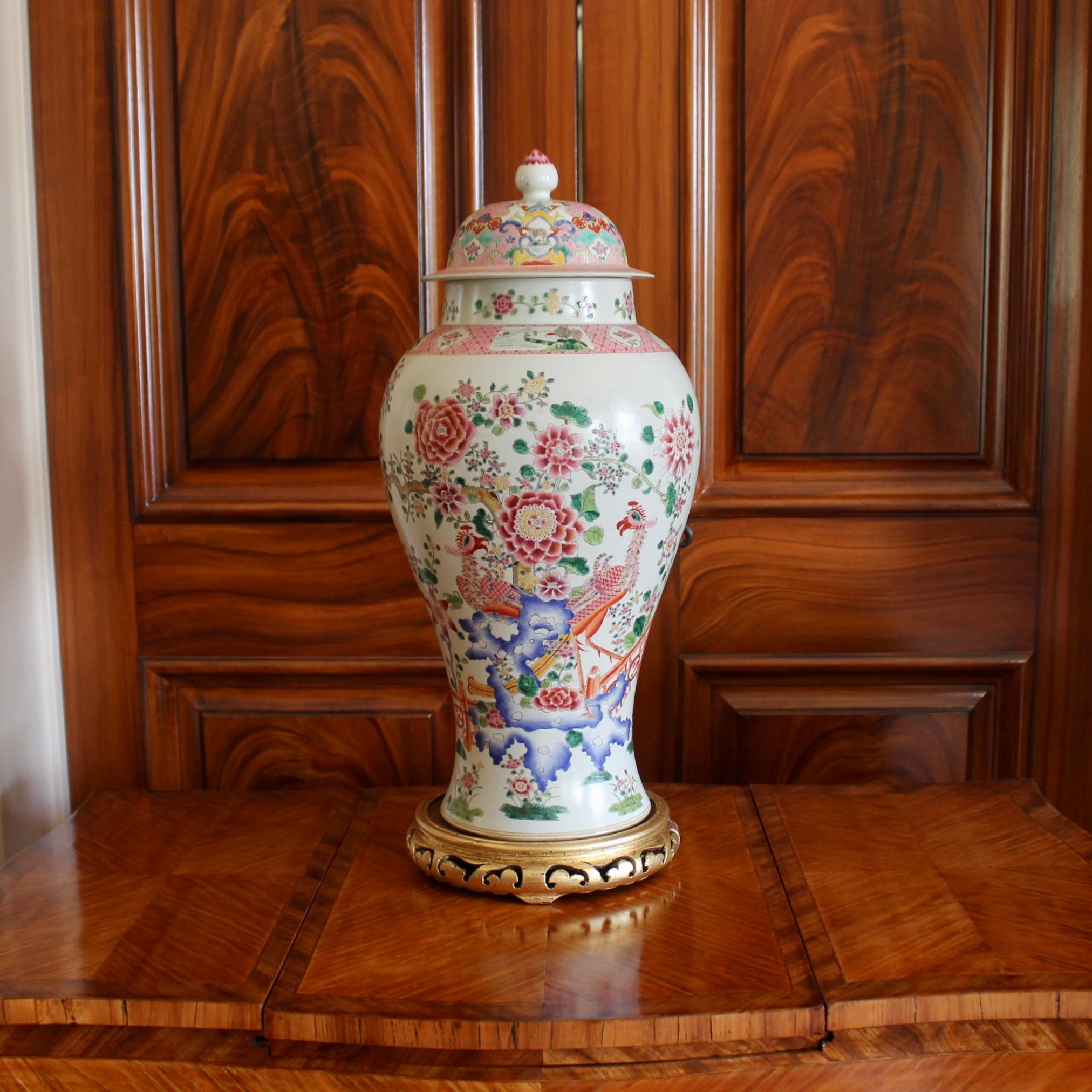 A large and very decorative Famille Rose porcelain jar featuring a traditional theme in Chinese porcelain, an idyllic garden with an ornamental fence and rockery, from which a flowering tree springs. Exotic birds perch within the scene. The tree is